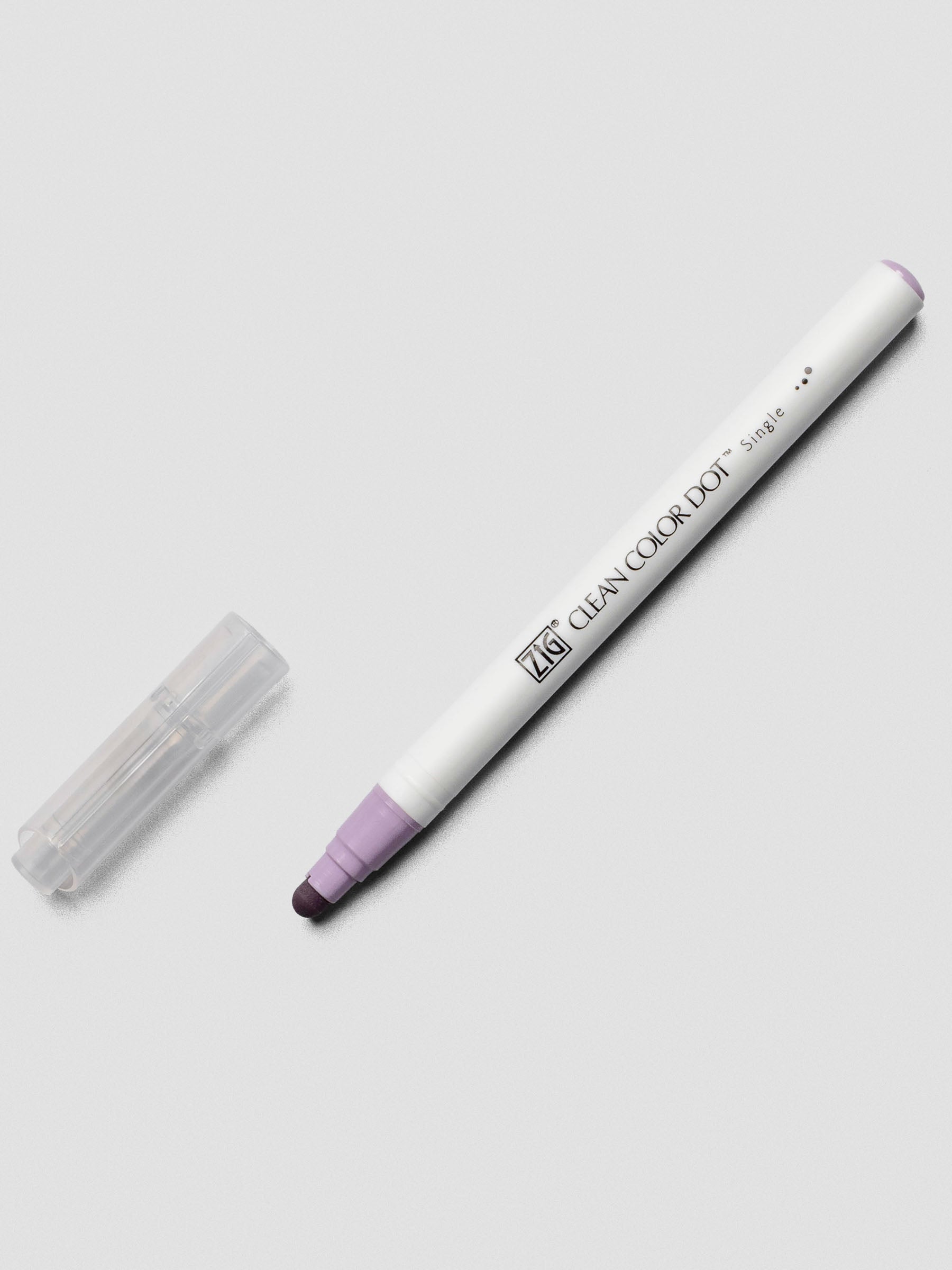 A Kuretake ZIG Clean Color Dot Marker in Wisteria, with the cap off to highlight its felt dot tip and subtle lavender tone on the tip.