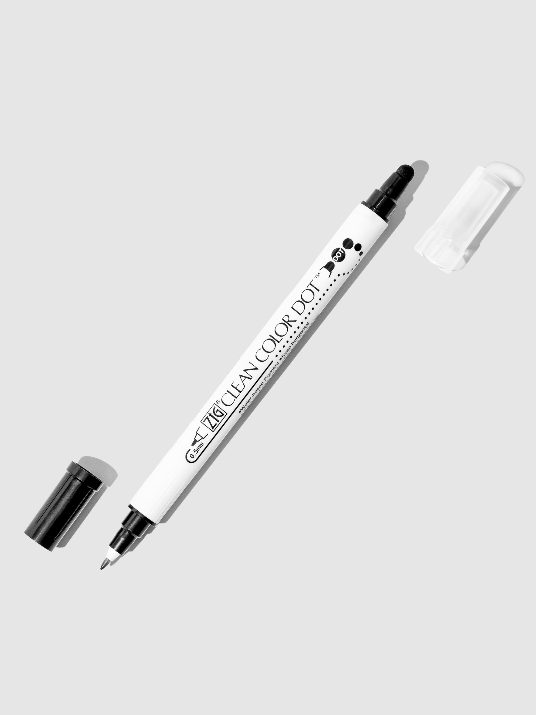 Black Kuretake ZIG Clean Color Dot Dual Tip Marker with caps off, displaying both the fine tip and dot tip on a light background.