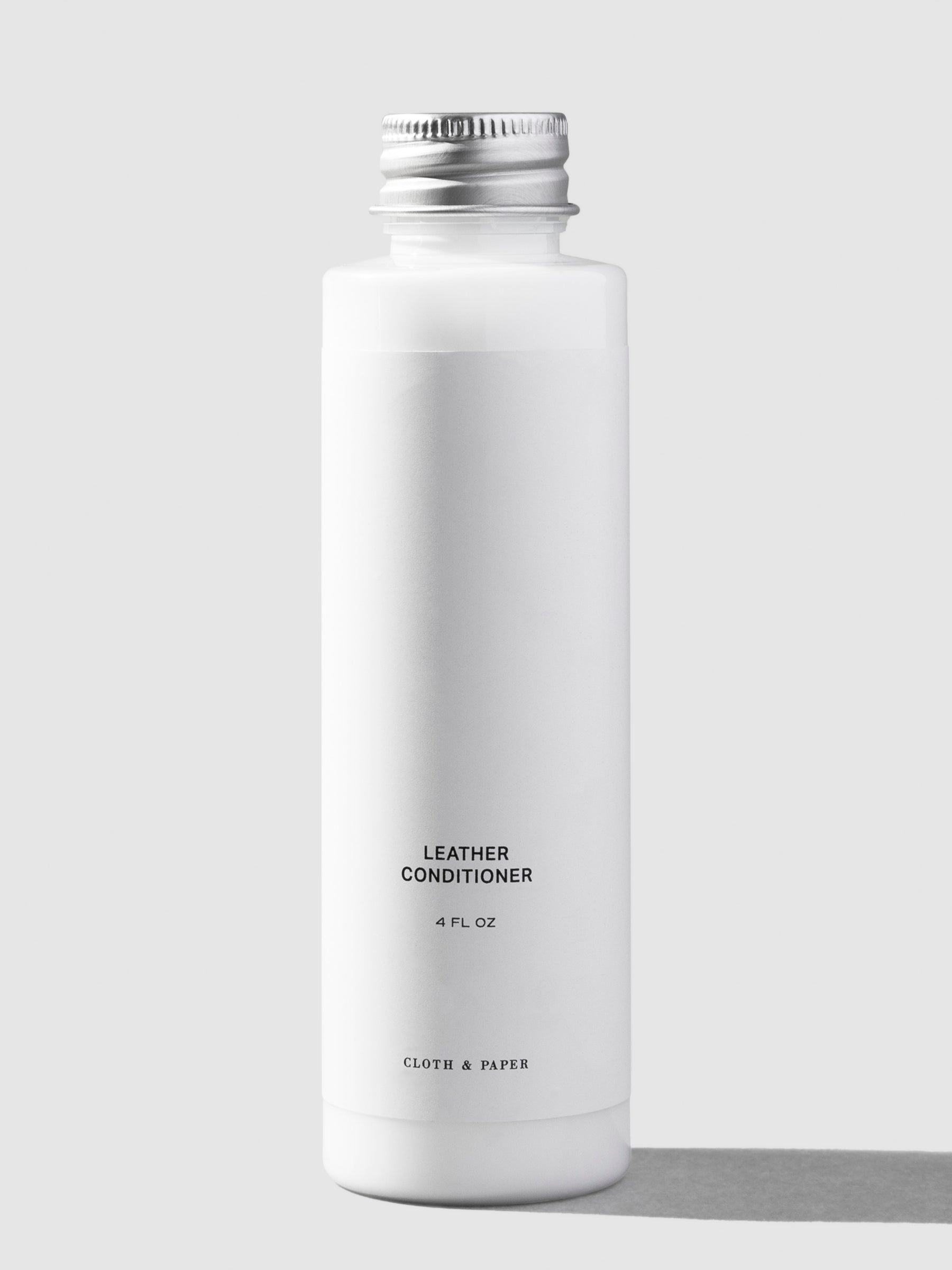 Leather conditioner, Cloth and Paper. Conditioner displayed on a neutral background.