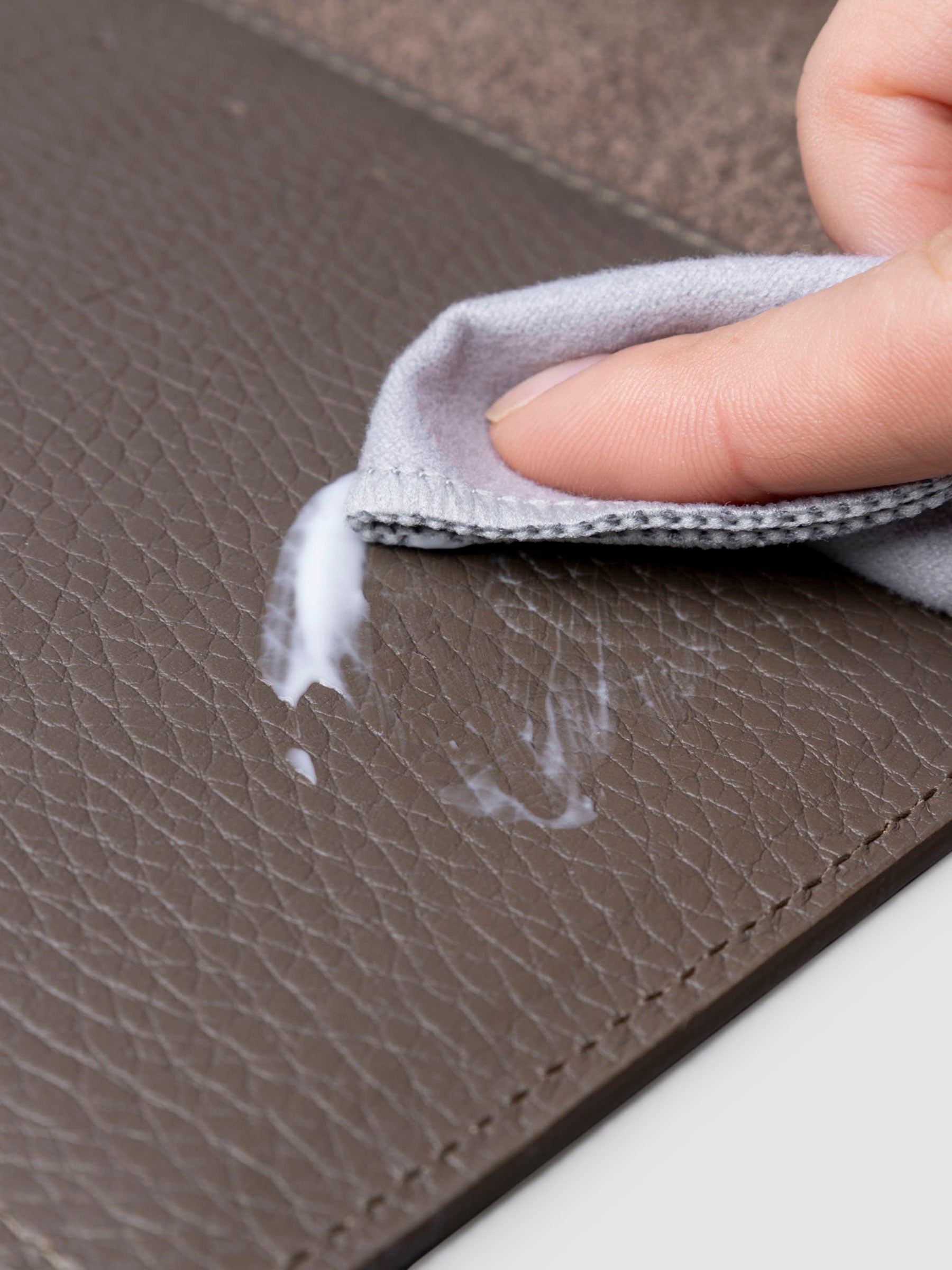 Conditioner in use inside a brown leather agenda.