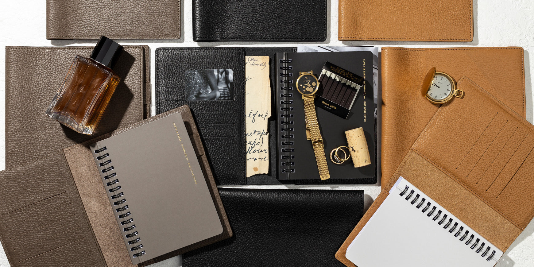 Several Heirloom Leather Folios are opened.  Inside the folios are our España Notebooks.  There are other personal accessories present.