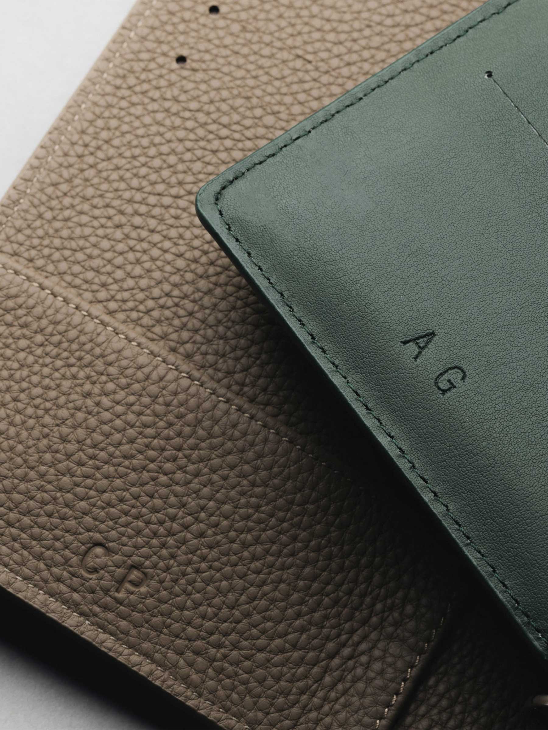 A couple leather planners are opened showing one corner of the planners.  Each planner has unique personalization of initials with Colorless Debossing.
