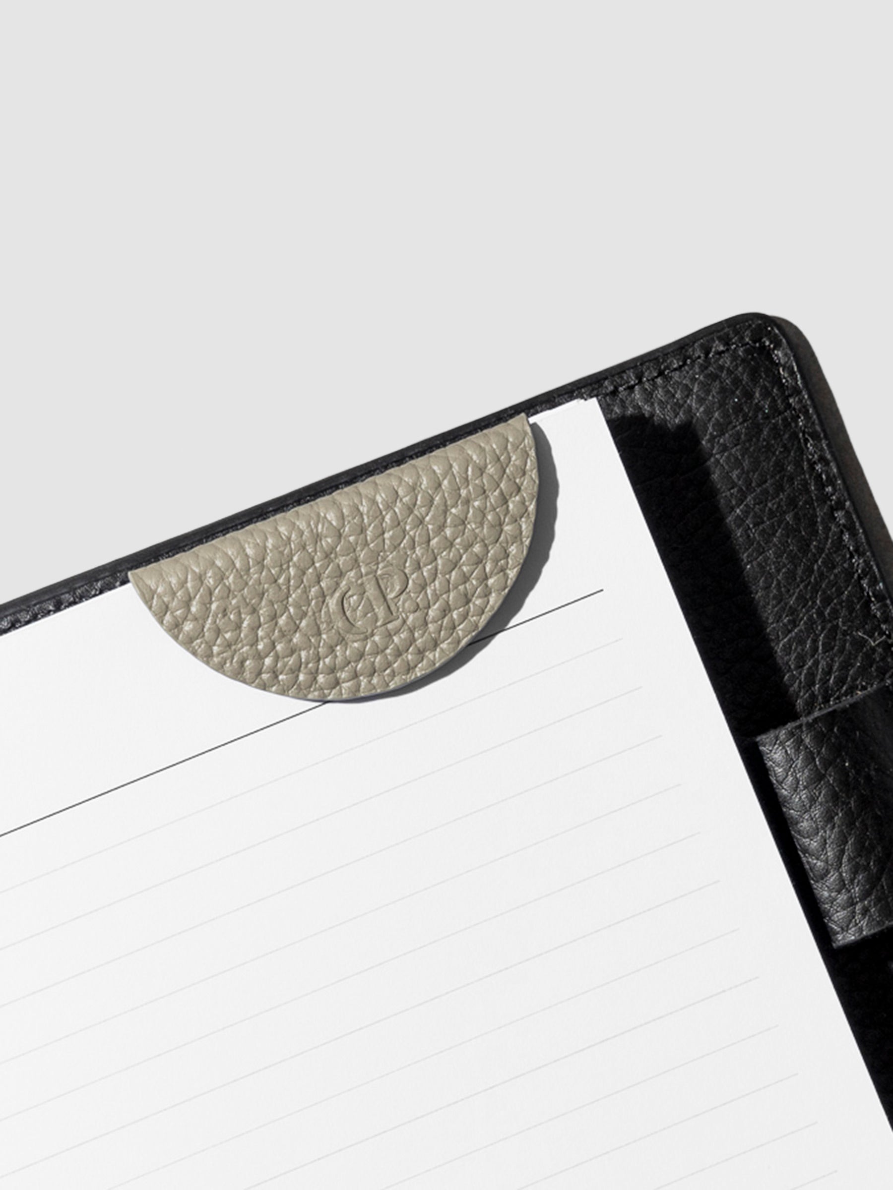 Beige bookmark in use inside a black leather agenda.