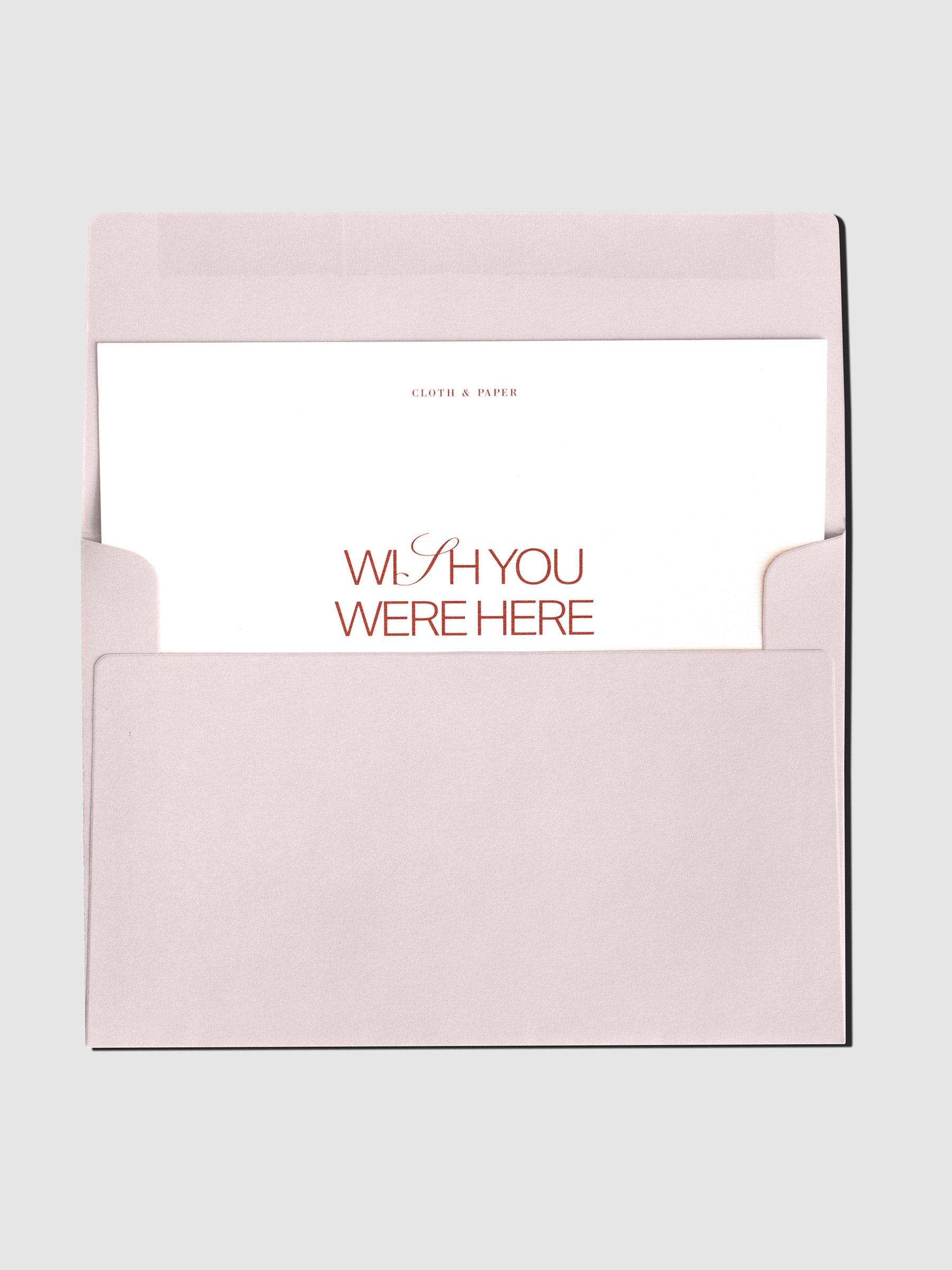 Postcard displayed inside its pink envelope on a neutral background.