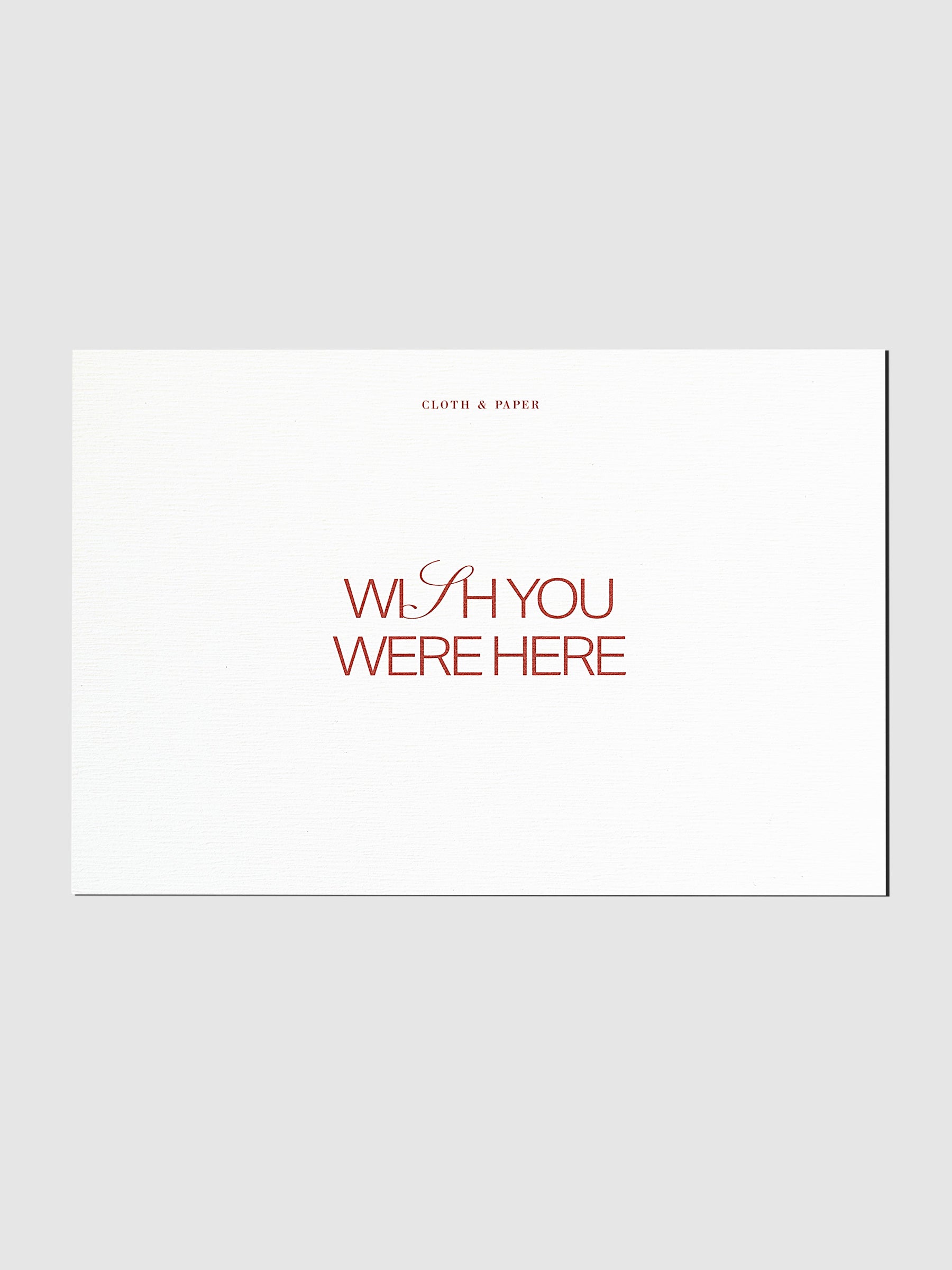 Wish You Were Here postcard displayed on a neutral background.
