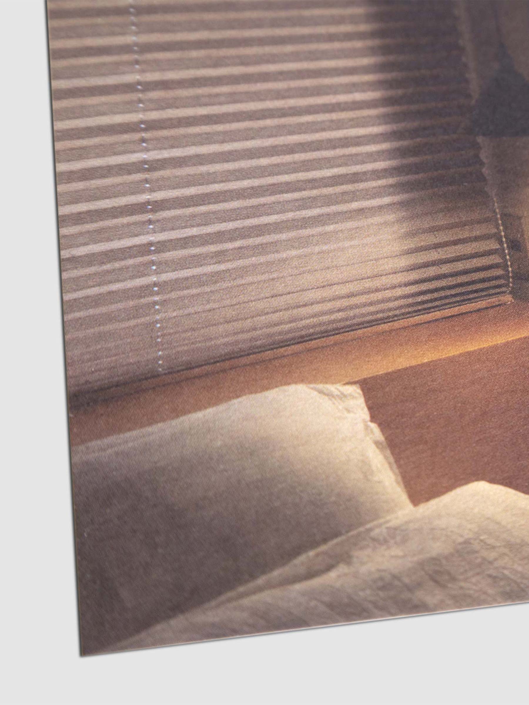 Closeup of postcard showing a bed and overhead lamp.