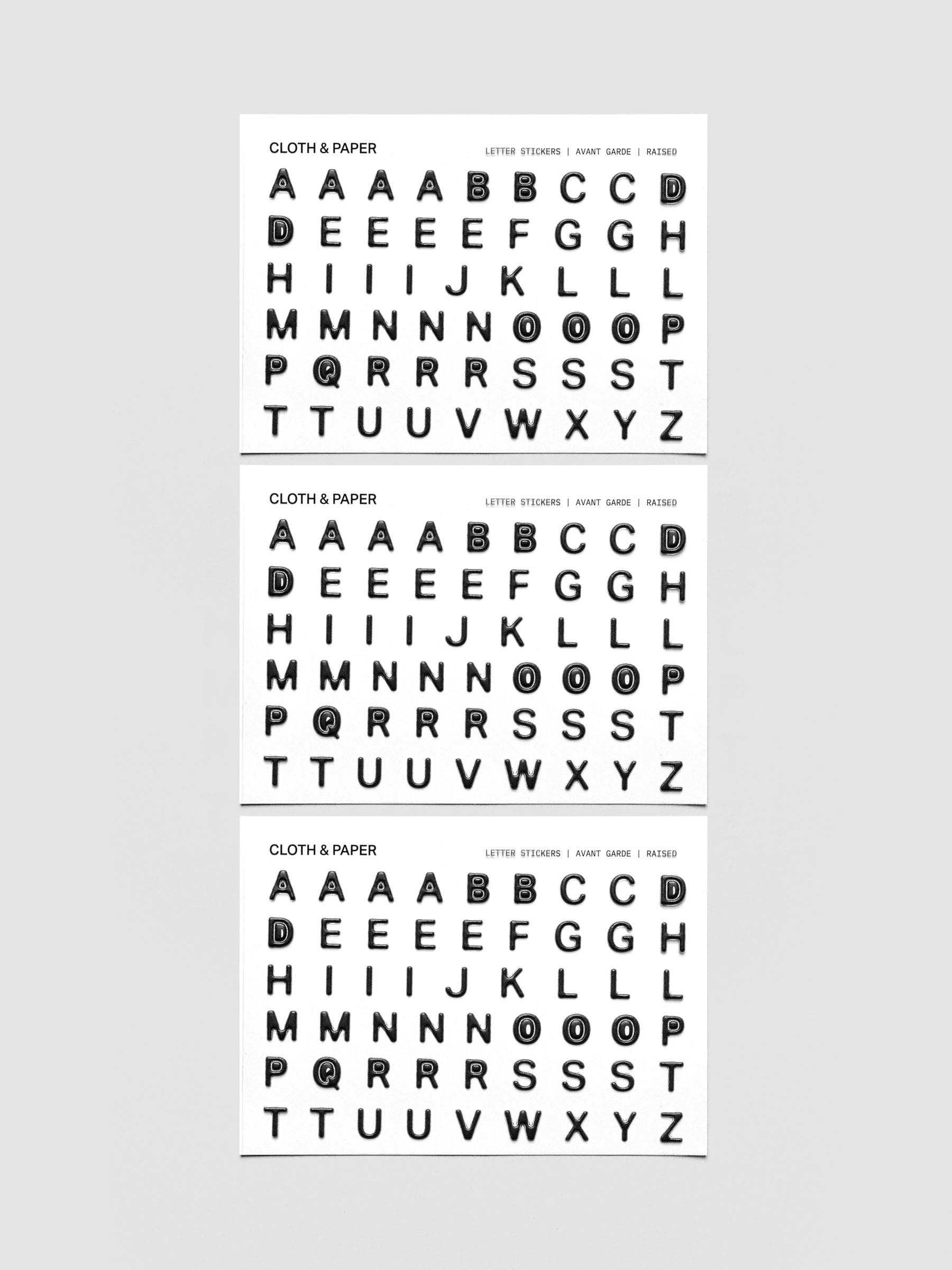 Three sheets of black raised letter stickers.