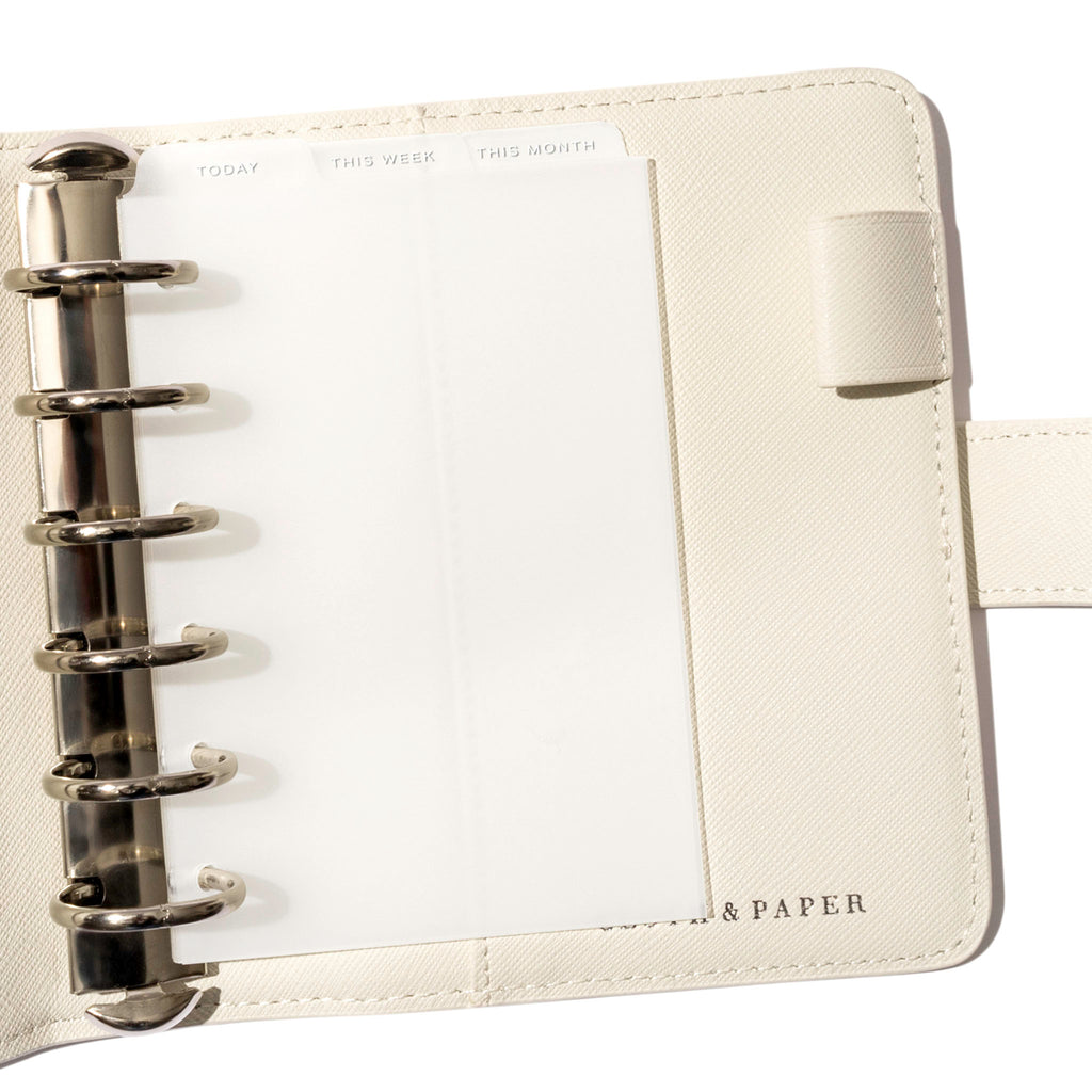 Pocket White Foil Cadence Tab Dividers displayed in a white leather planner.
