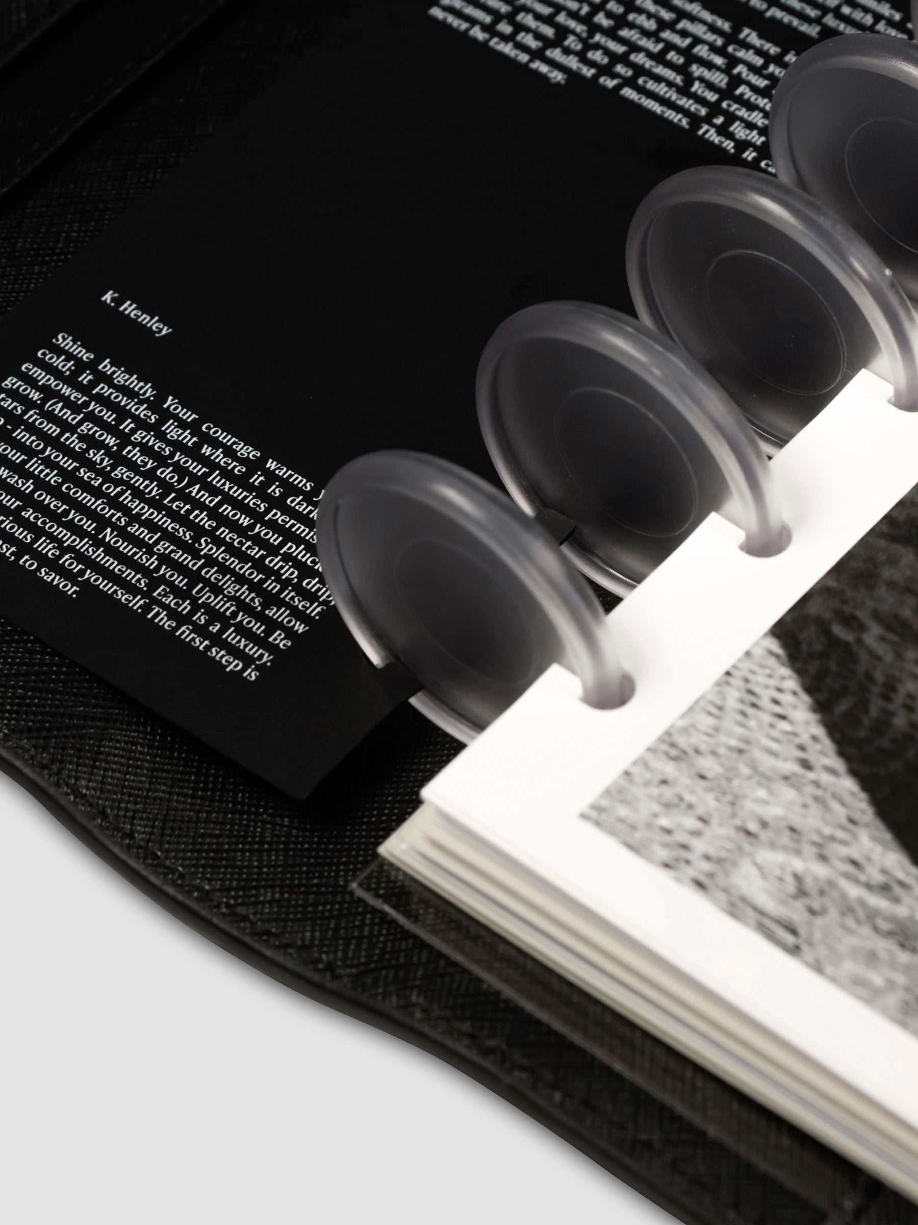 Close up on the bottom of the half dashboard and the bottom left corner of the full dashboard styled inside a discbound planner. Prose written by K. Henley is visible to the half dashboard on the left, while black and white imagery is visible on the full dashboard to the right.