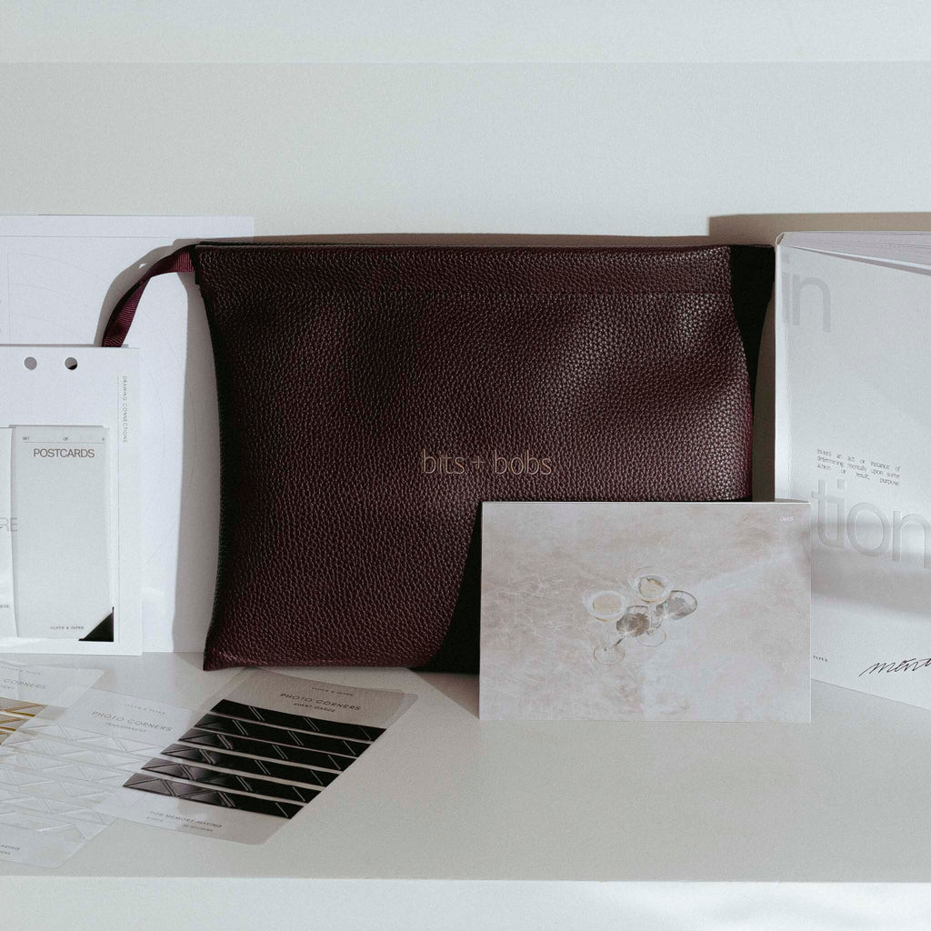 An image representing spoilers from our March Planning + Stationery Subscription Box.  Displayed on a desk is Vegan Dust Bag with embroidery that reads bits + bobs and other planner accessories. 