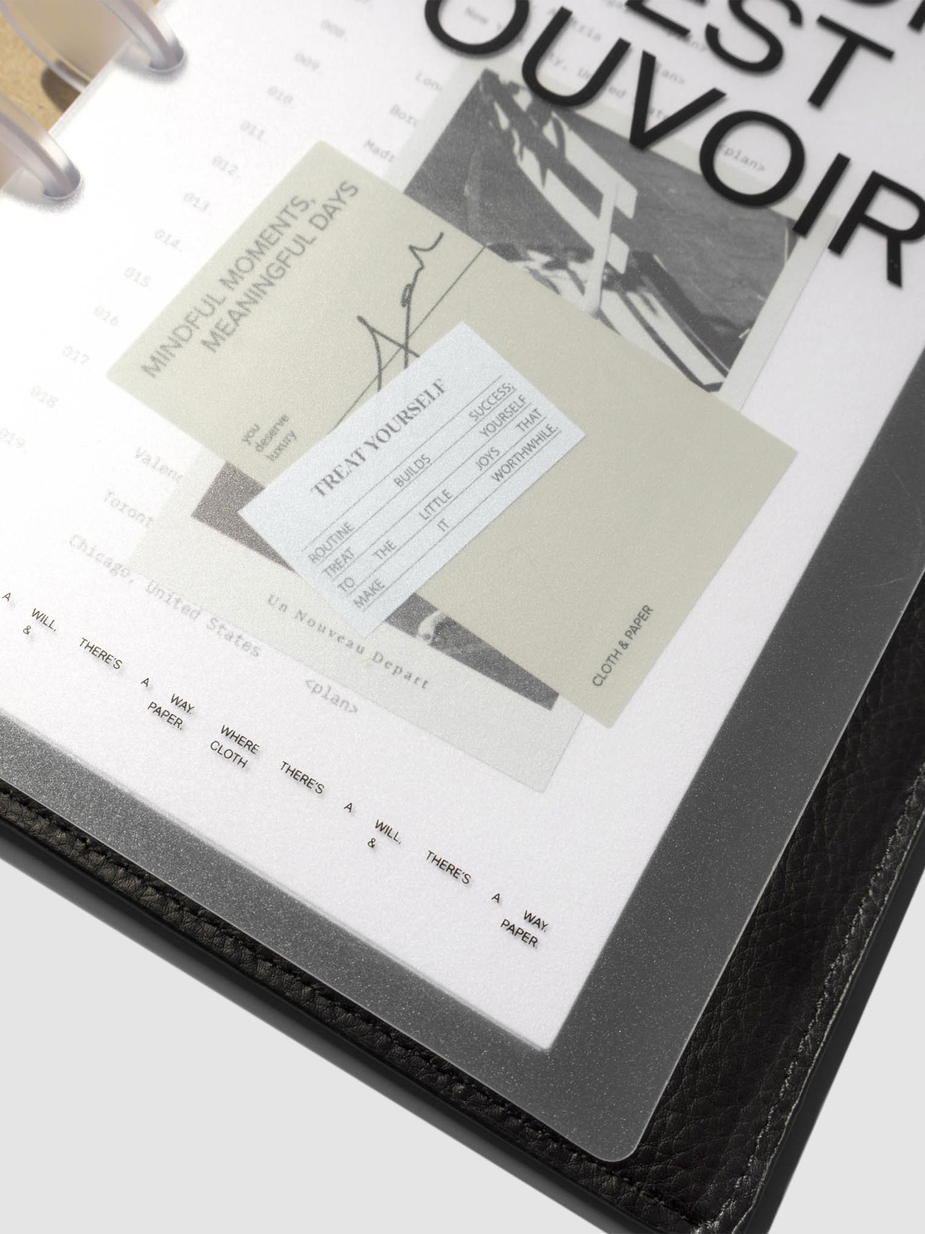 Close up image of the bottom of the Moments Cover and Dashboard displayed in a black folio with clear discs turned at a slight angle on a neutral background.