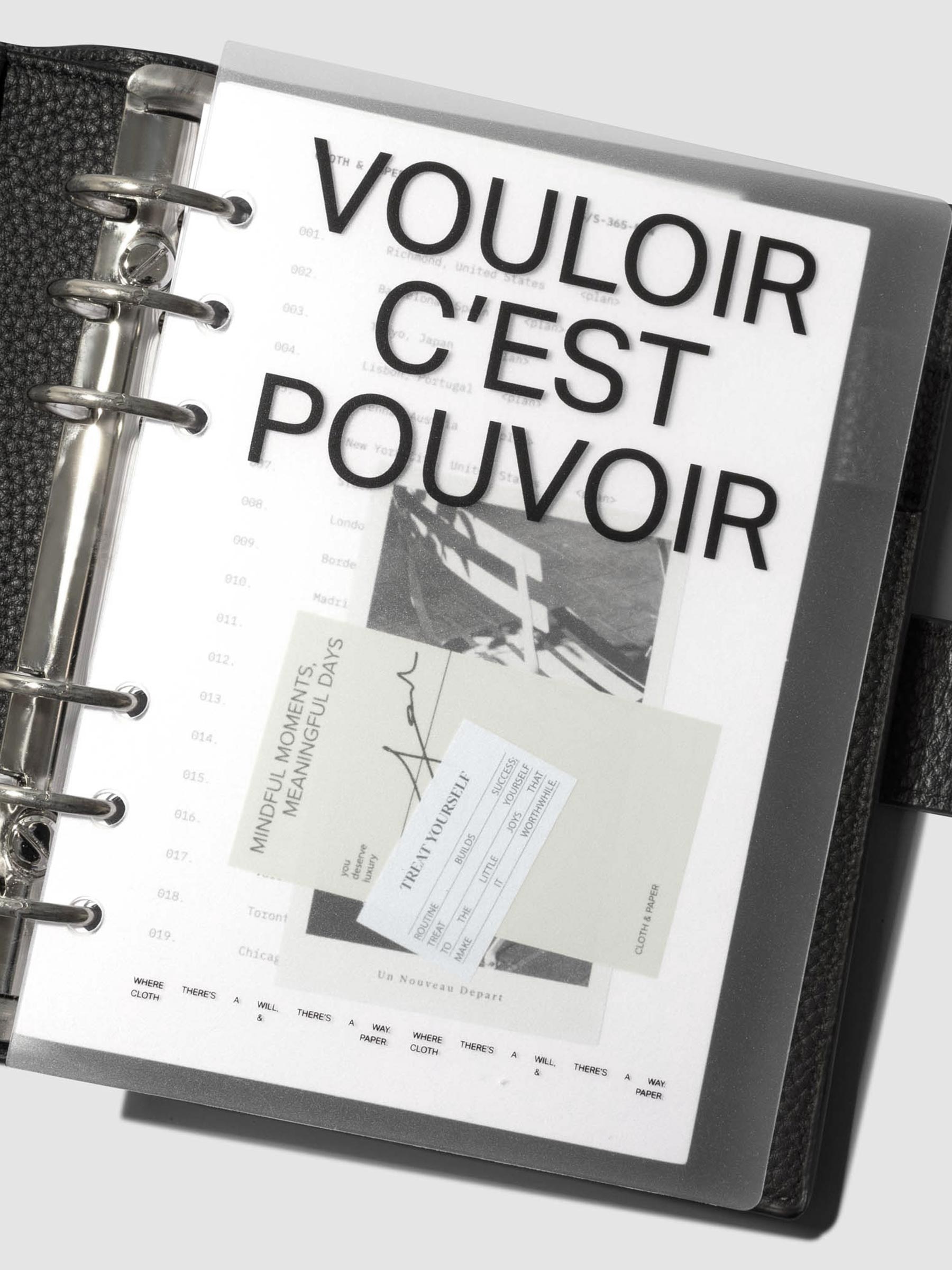 Moments Cover and Dashboard displayed in black 6 ring agenda turned at a slight angle on a neutral background.