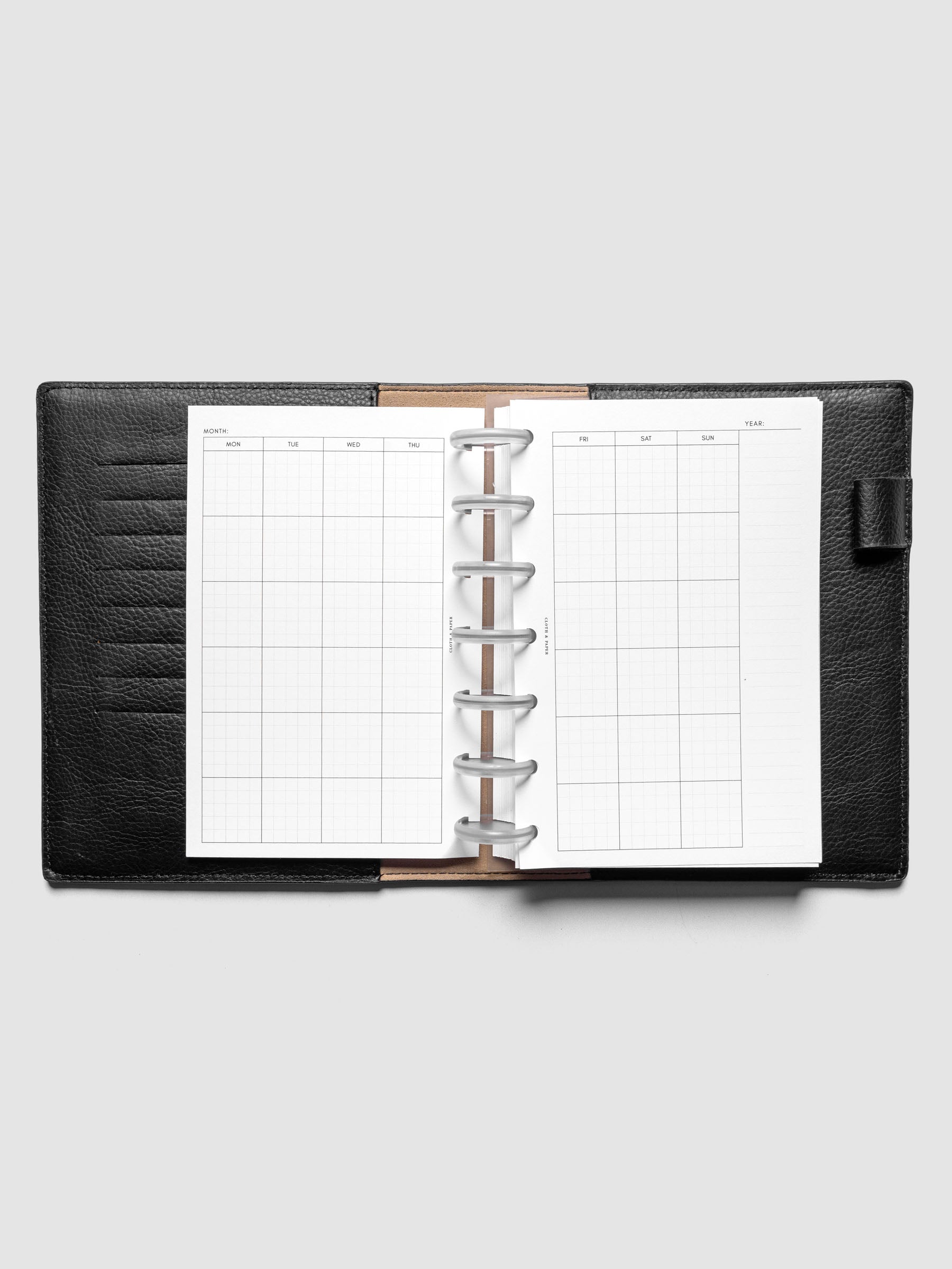 HP Mini Monthly Graph Planner Inserts shown discbound in a black leather folio.