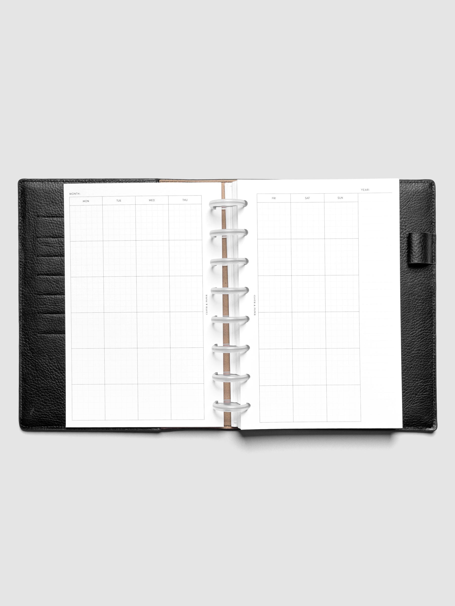 Half Letter Monthly Graph Planner Inserts shown discbound in a black leather folio.