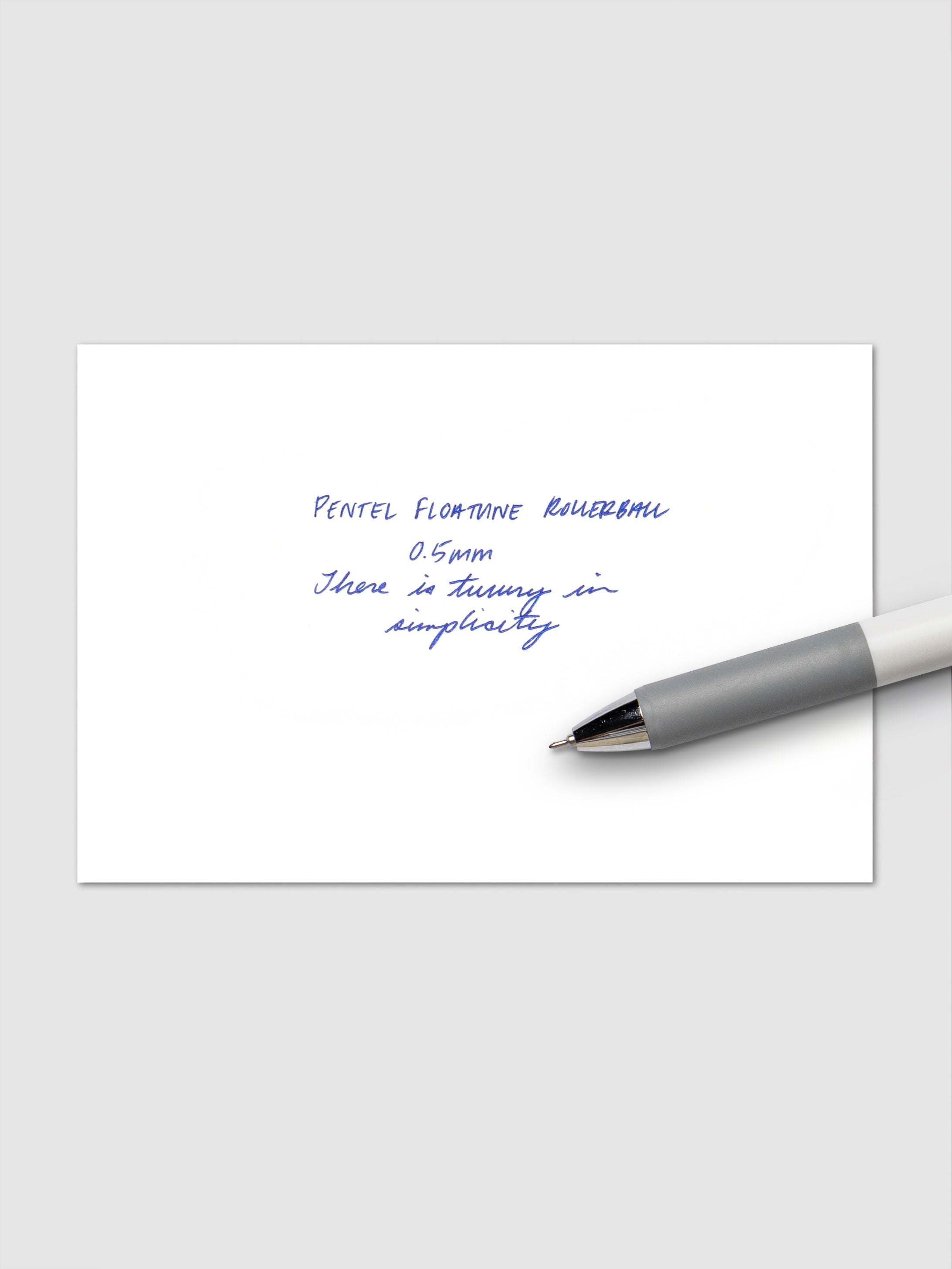 Pentel Floatune Gel Pen 0.5mm blue ink. Pen resting on pen test sheet displaying writing sample.