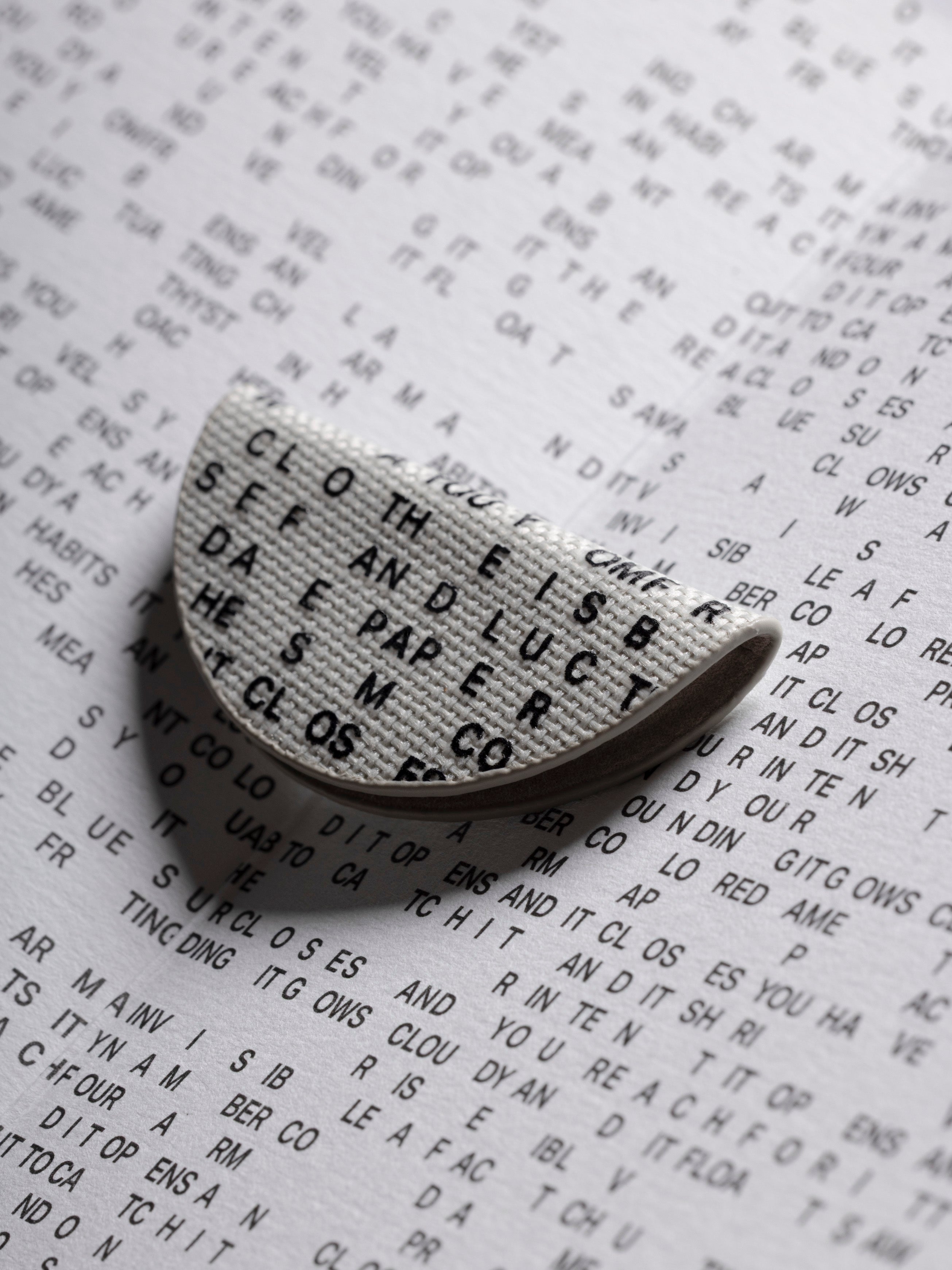 Magnetic Bookmark | Bookcloth | Letters shown folded in half resting on the inside cover of the Inverted Graph Notebook in CP Petite.