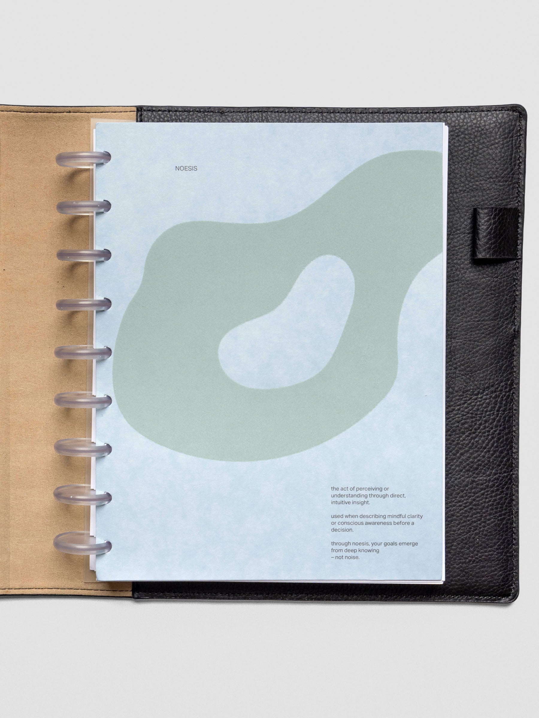 Blue speckle cardstock planner dashboard with organic shape design flocked in blue-green with text design shown in HP Classic size with disc binding in a leather folio.
