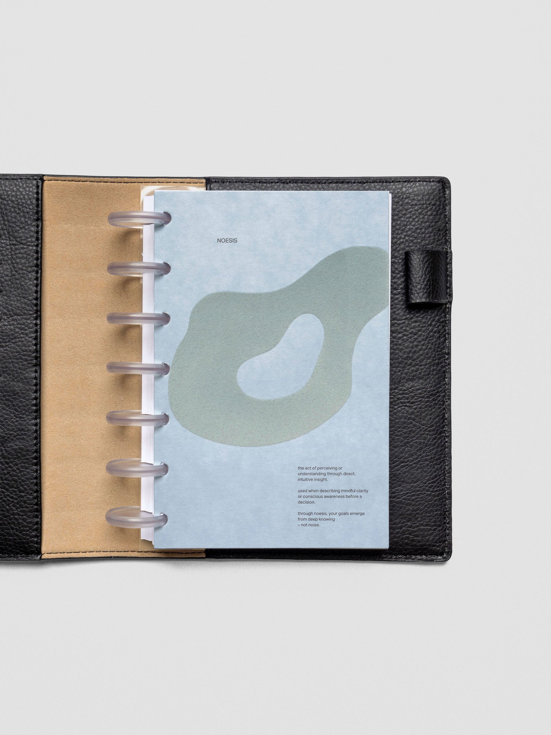 Blue speckle cardstock planner dashboard with organic shape design flocked in blue-green with text design shown in HP Mini size with disc binding in a leather folio.