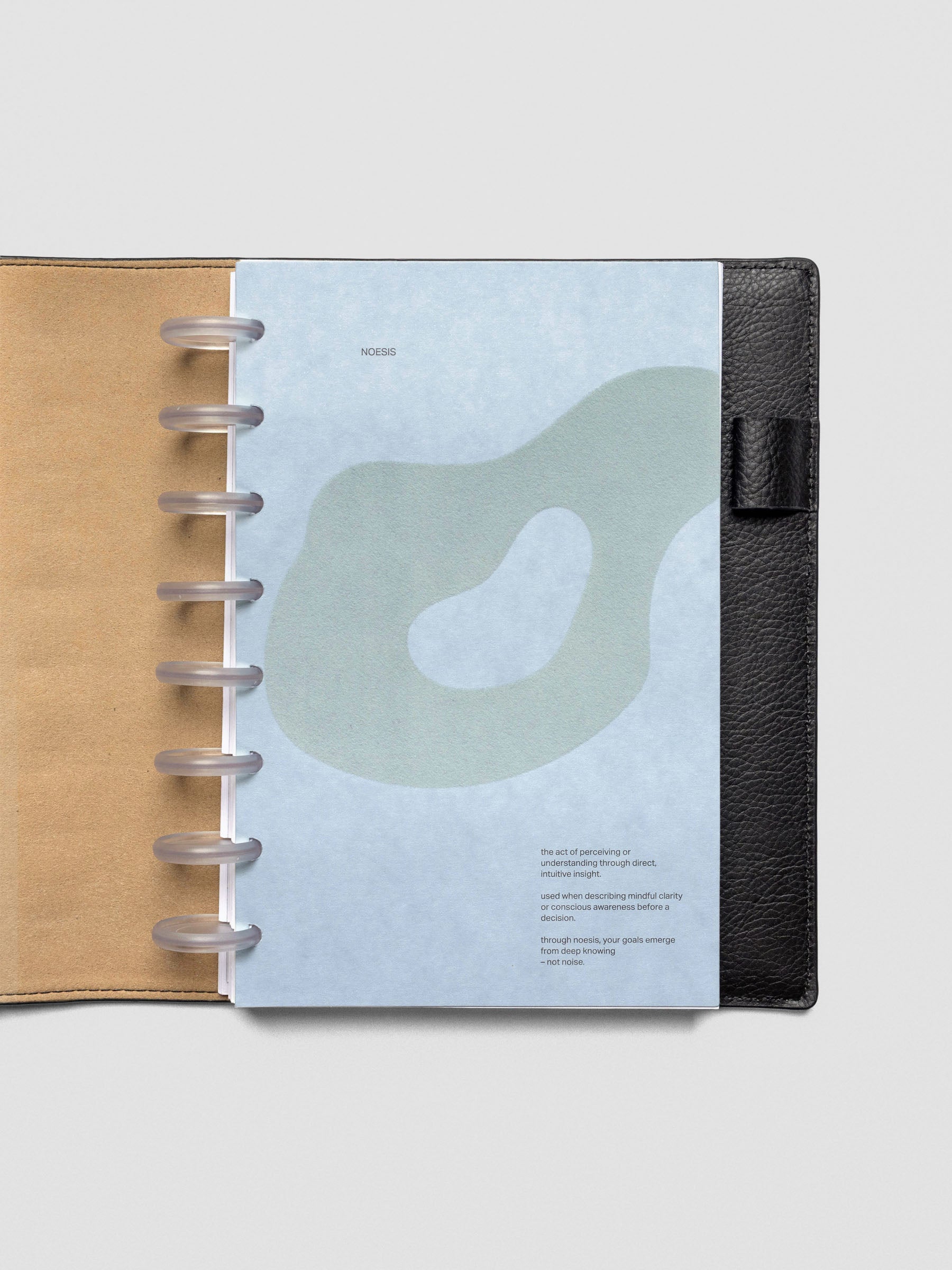 Blue speckle cardstock planner dashboard with organic shape design flocked in blue-green with text design shown in Half Letter size in a leather folio with disc binding.