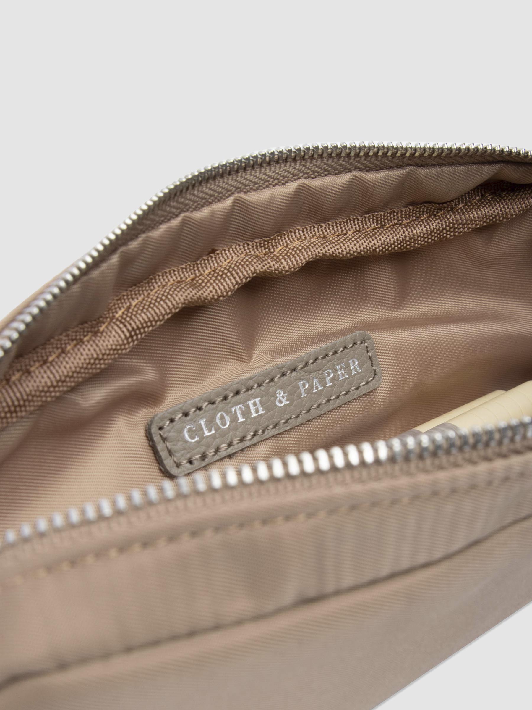 Closeup of Cloth and Paper logo inside of pencil pouch. Color featured is fossil.