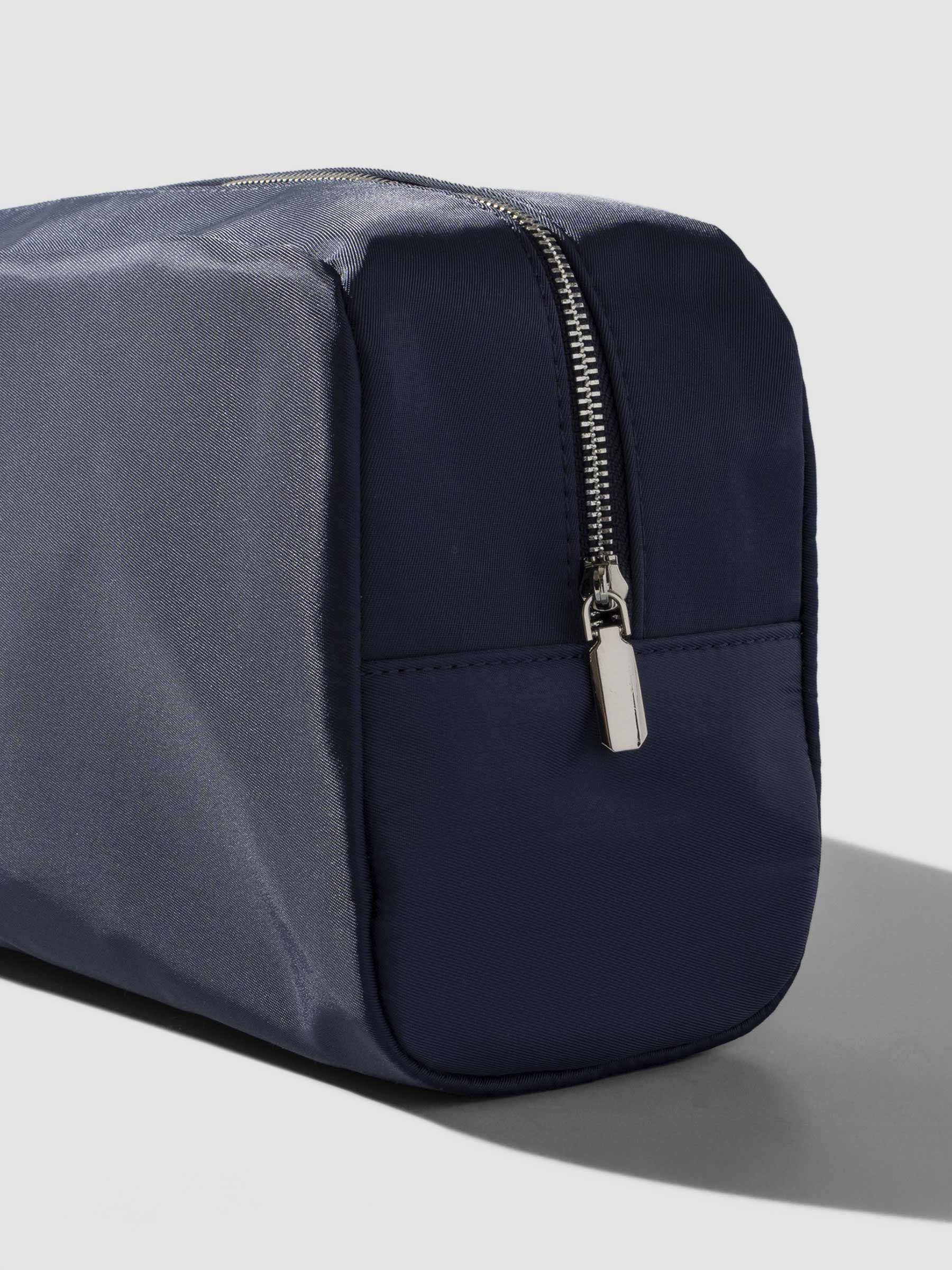 Apollo blue pouch shown from a three quarter angle on a neutral background, zipper side exposed.