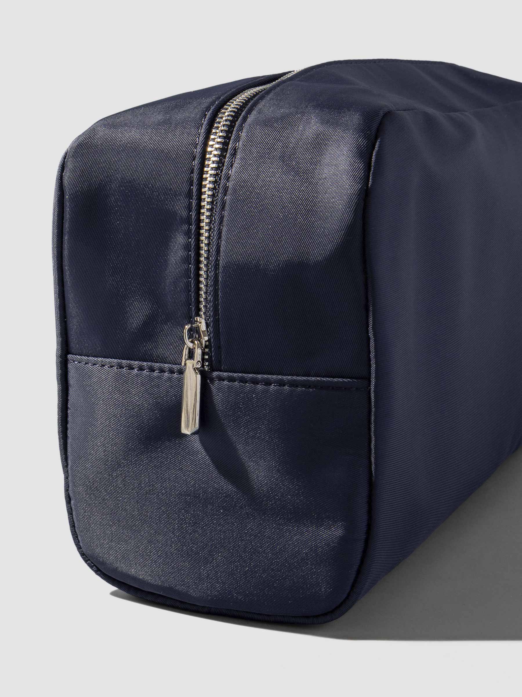 Apollo blue pouch shown from a three quarter angle on a neutral background, zipper side exposed.