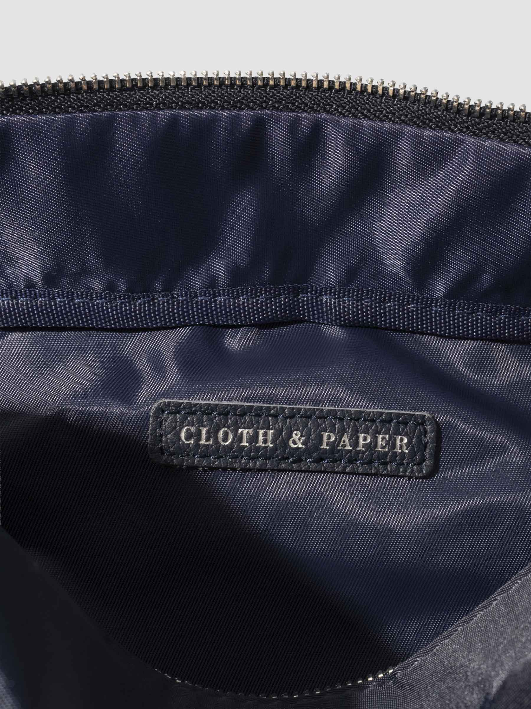 Closeup of interior of bag. A vegan leather tag is inside the bag with "Cloth & Paper" stamped on it with silver foil.