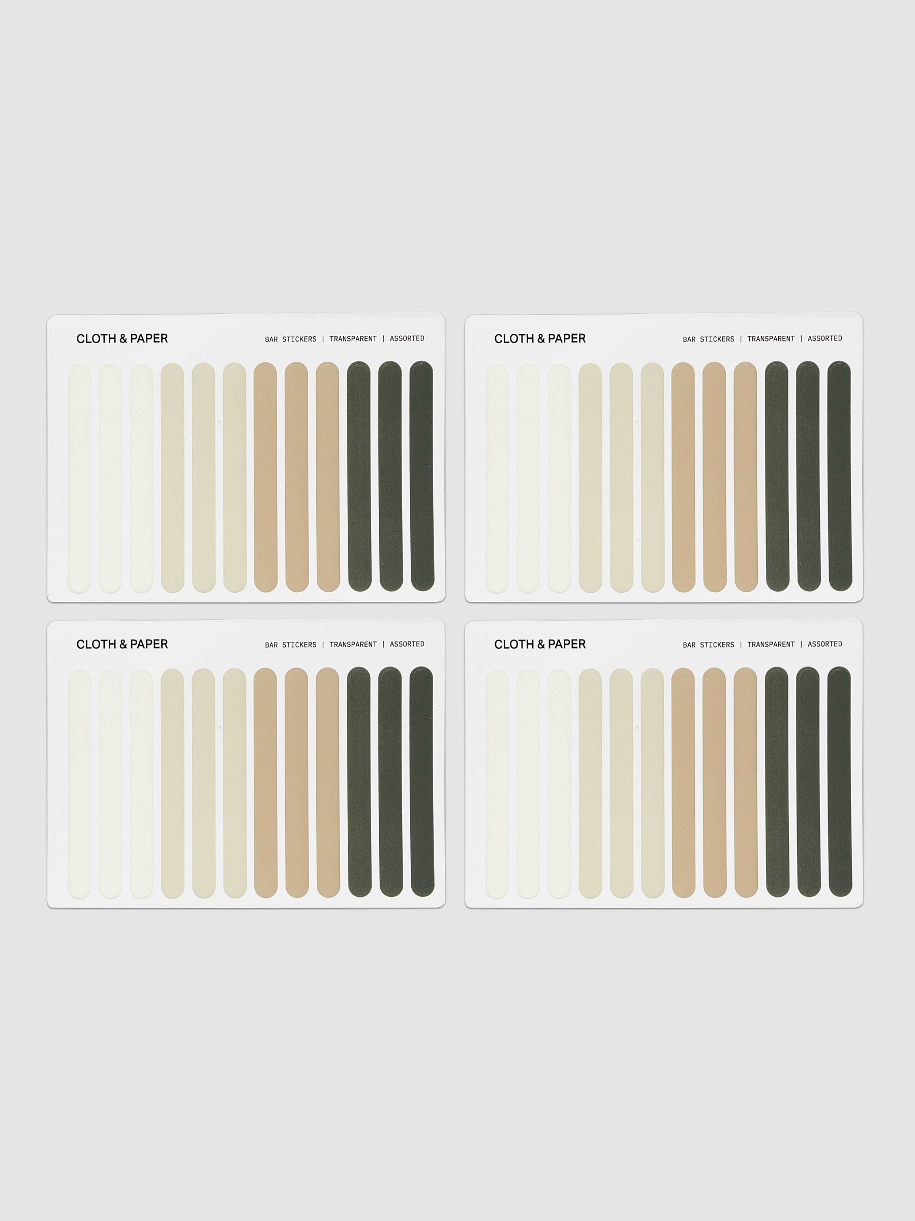 Four fabric color swatch cards arranged in a 2x2 grid on a light gray background. Each card shows vertical fabric samples in neutral tones including cream, beige, tan, and dark olive green, with the text 'CLOTH & PAPER' at the top of each card.