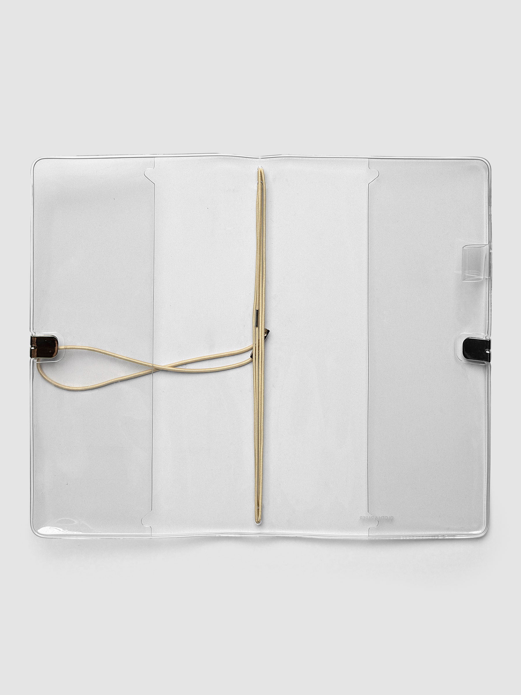 Clear Vinyl Travel Notebook Cover in A5 Slim shown open flat with the interior pockets and bungee strings visible.
