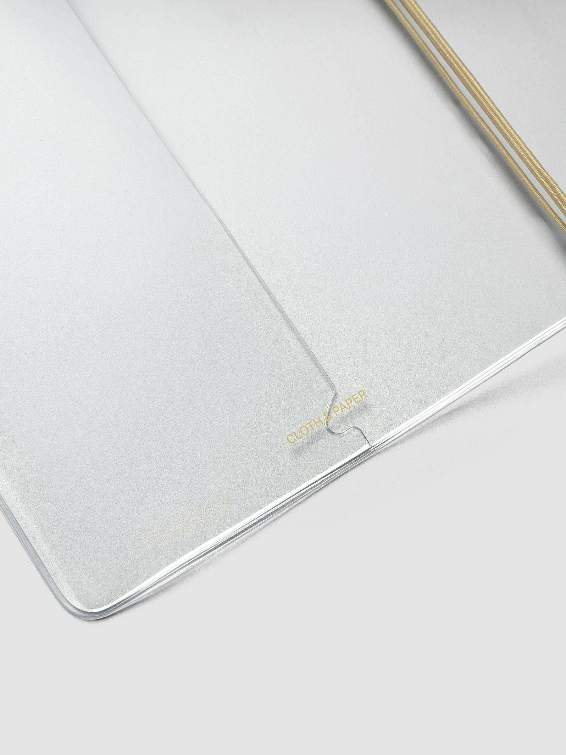 Close-up of the Clear Vinyl Travel Notebook Cover in A5 Slim at an angle, showing the edge and bungee string.