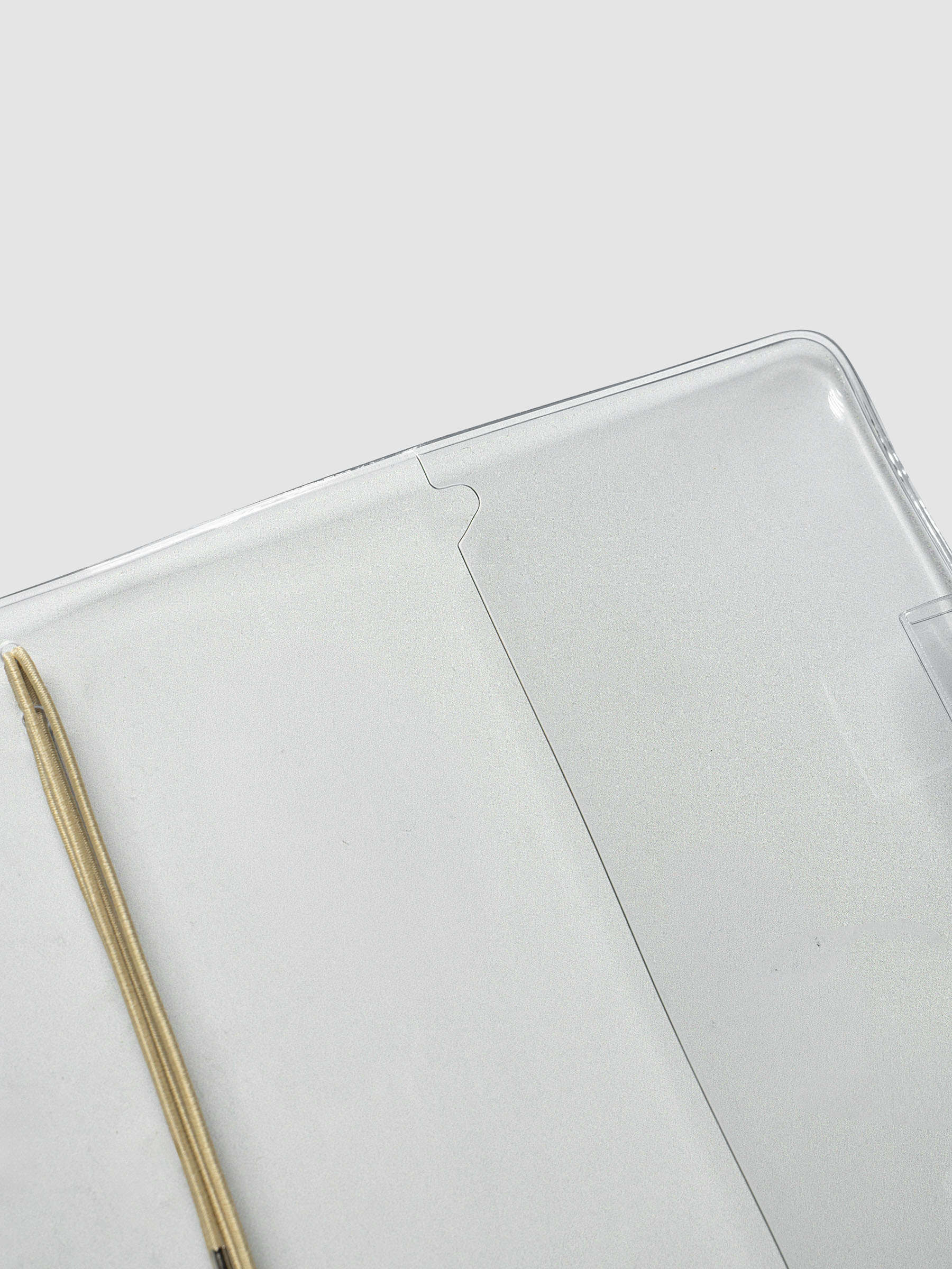 Clear Vinyl Travel Notebook Cover in A5 Slim at an angle, showcasing the rear pocket, on a neutral background.
