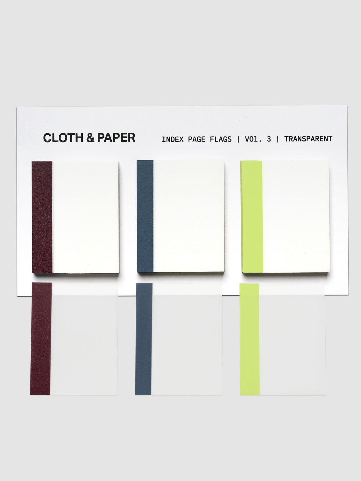 A set of transparent index page flags from Cloth & Paper, Volume 3, shown in a clean studio layout. The flags feature separate deep wine, blue, and lime green borders with a clear, semi-transparent base, displayed against a light gray background.