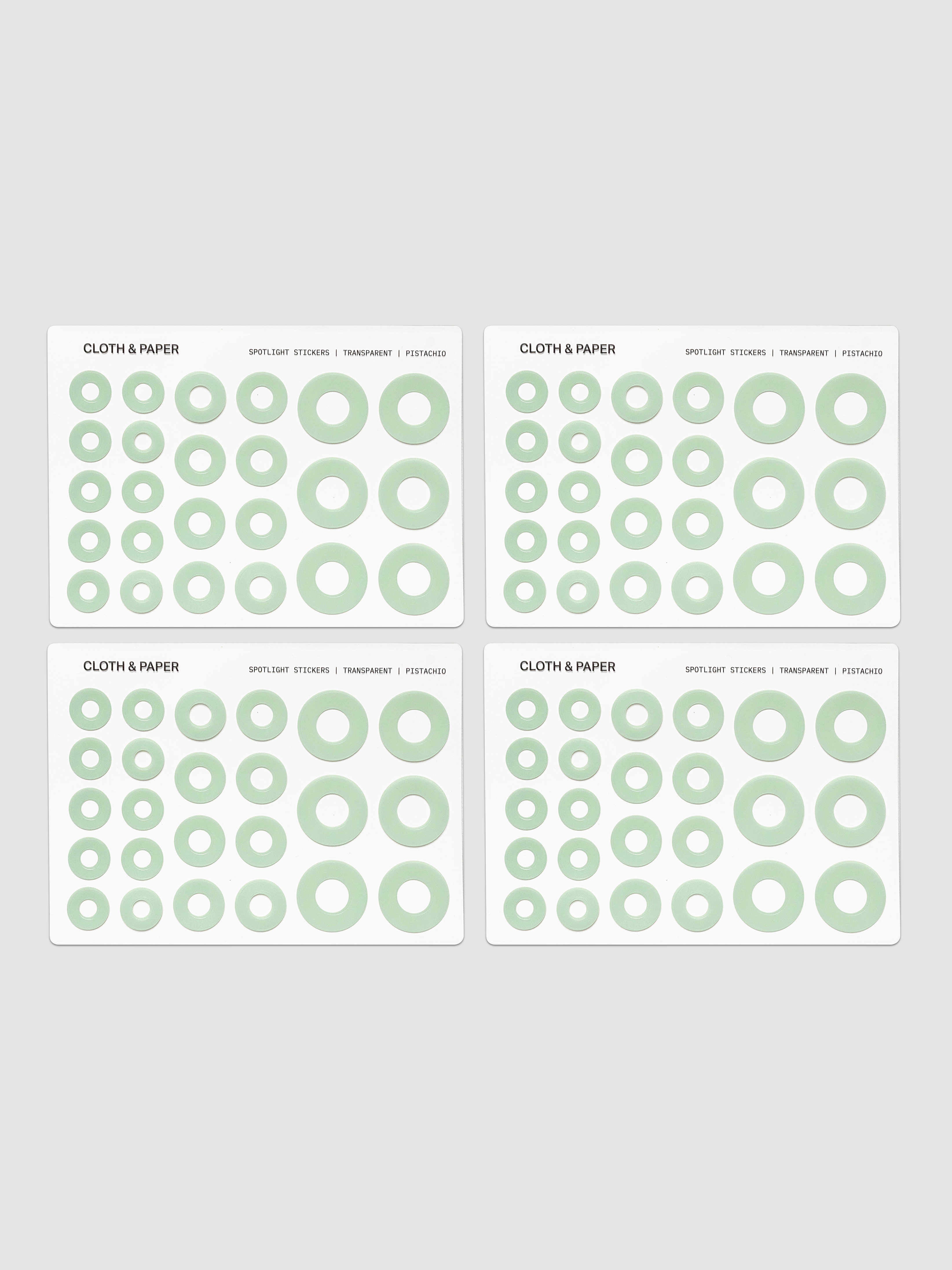 Four sheets of circular stickers of various sizes in light green, arranged on a light gray background.