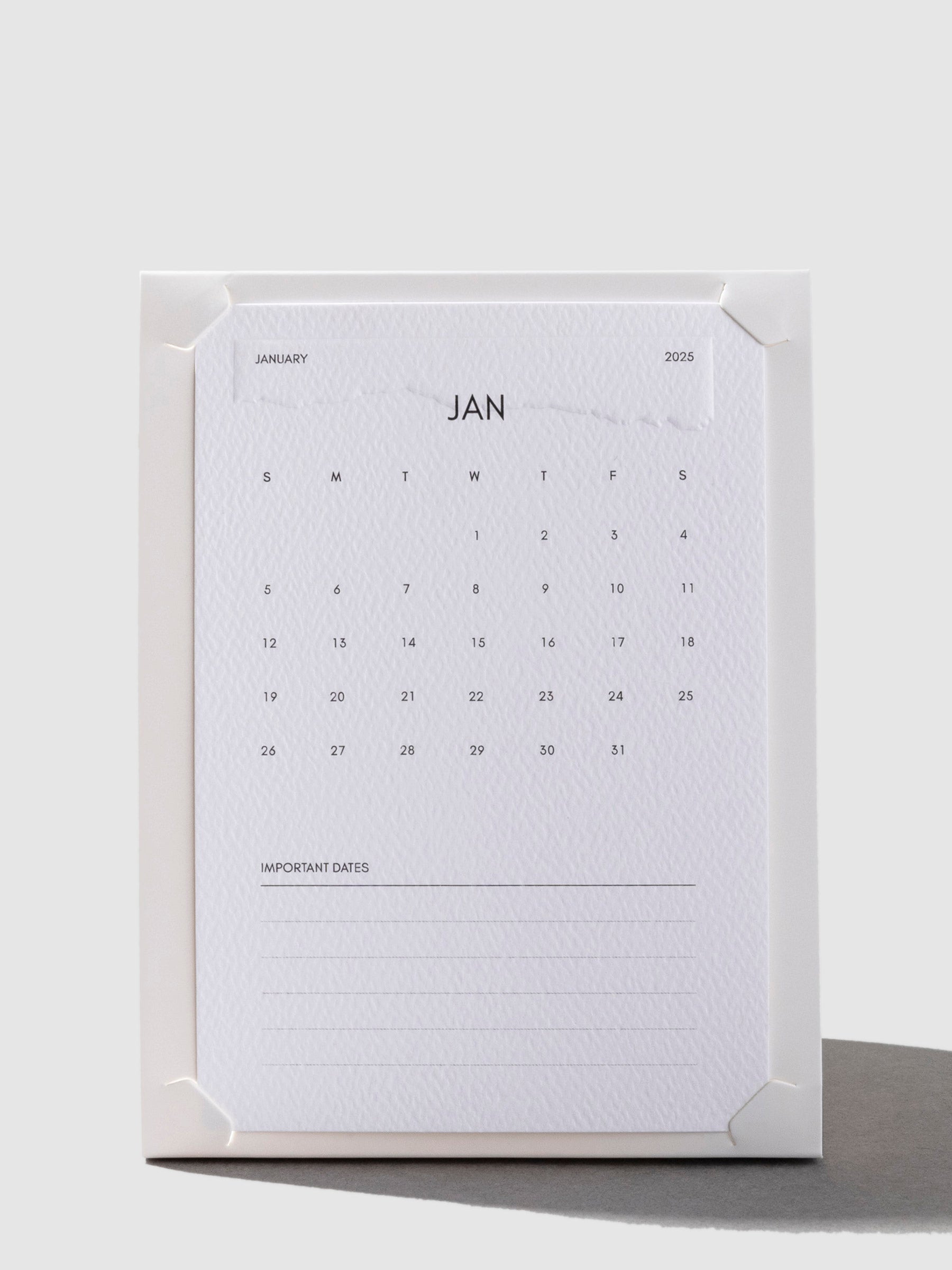 Stand shown with a 2025 calendar card fit inside of it on a neutral background.