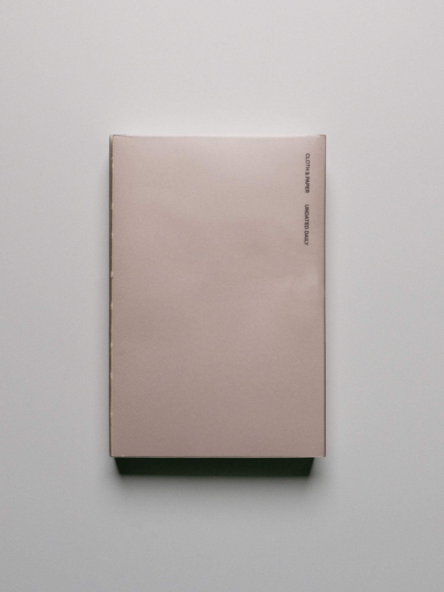 Perfect Bound Notebook | CP Petite | Undated Daily | Verona shown closed, laying flat, on a neutral background.