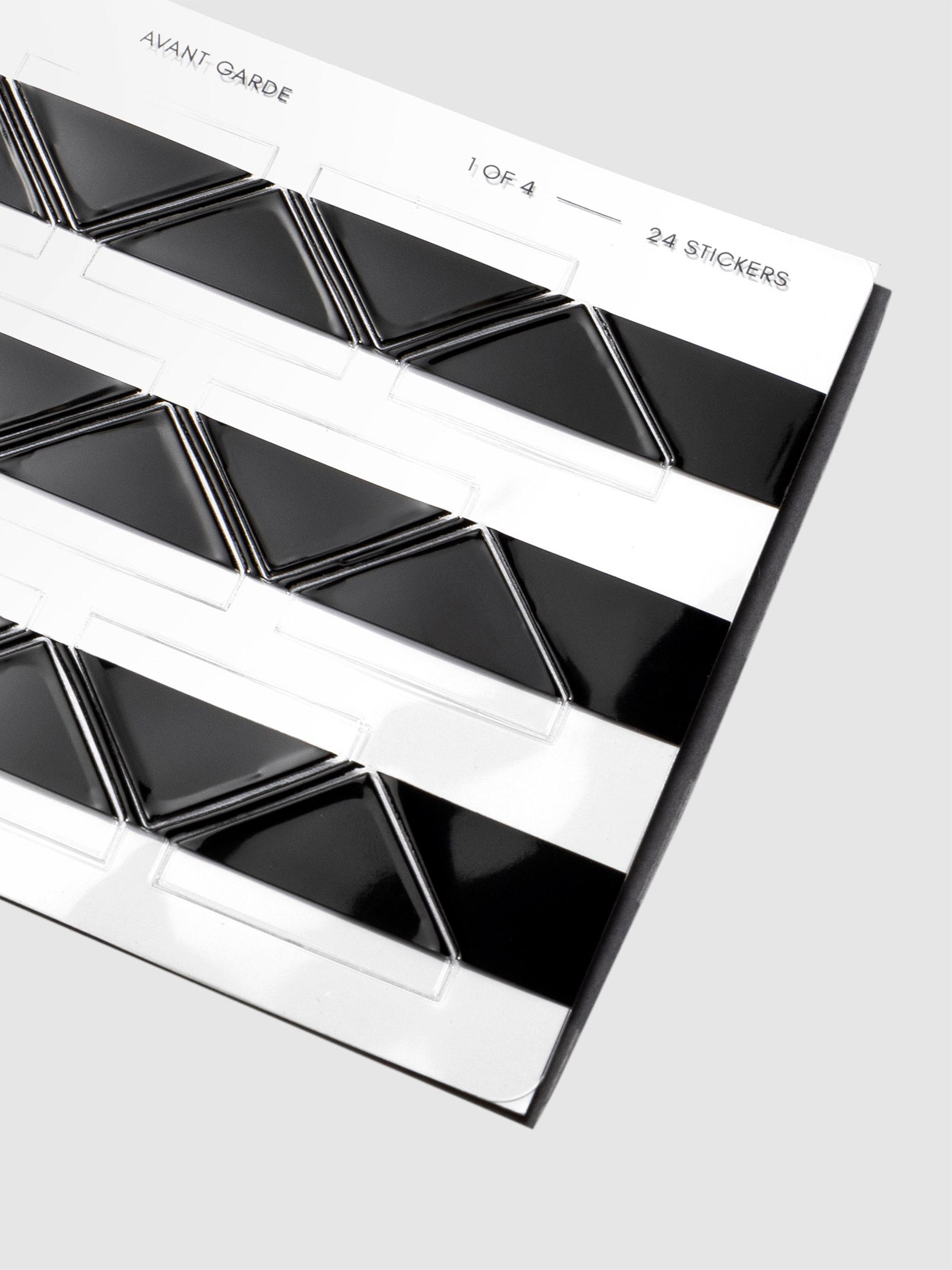 Closeup of black photo corners in their packaging displayed on a neutral background.