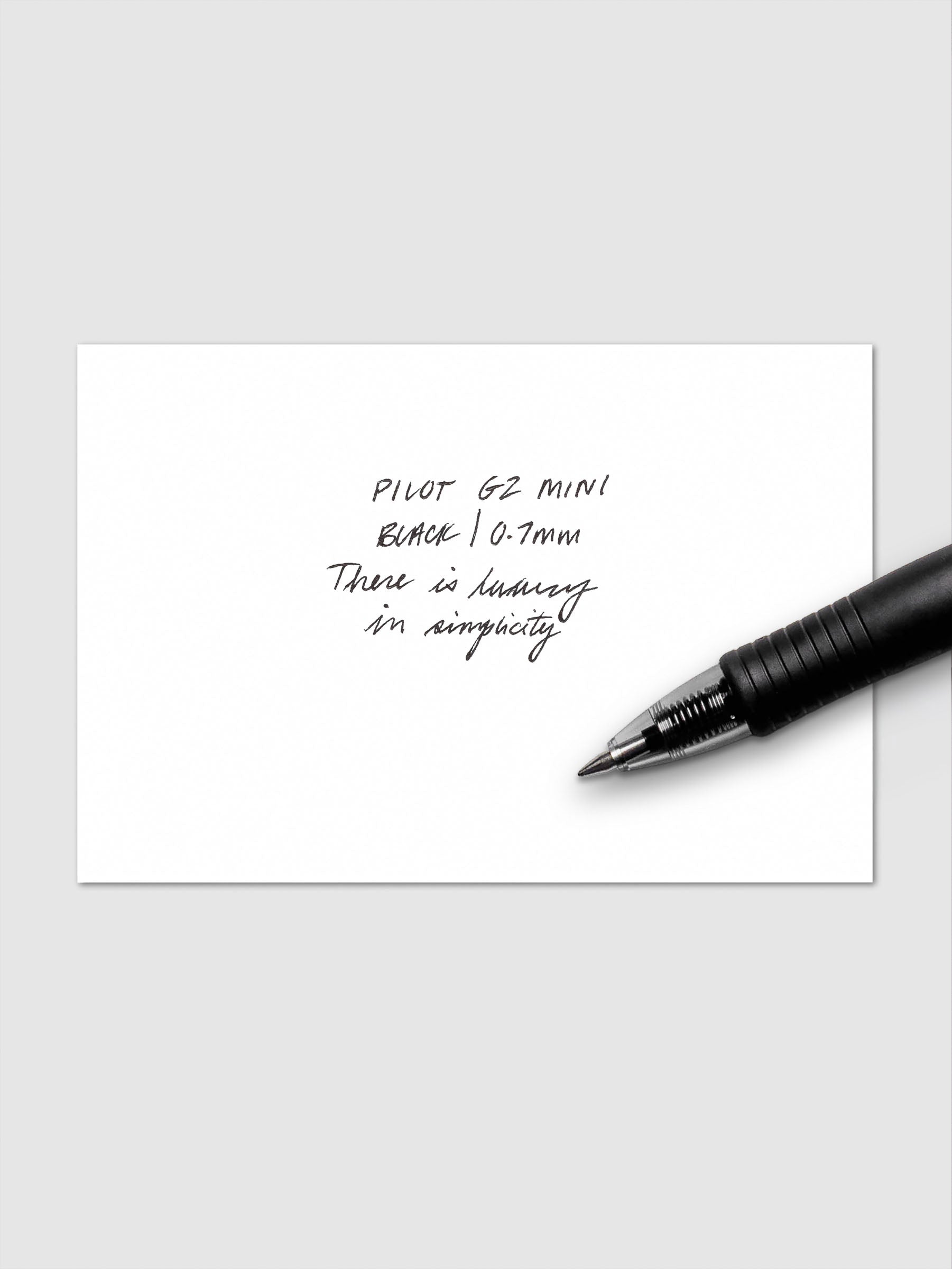 Pilot G2 Mini Black Pen in 0.7 mm shown laying on top of a writing sample.