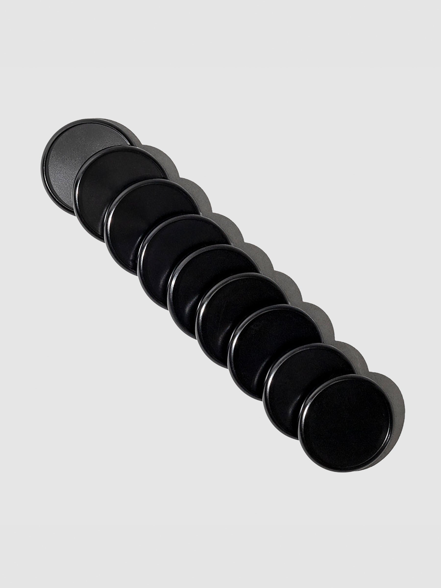 Black aluminum planner discs, 1.5 inch size, set of nine laid out on a flat surface.
