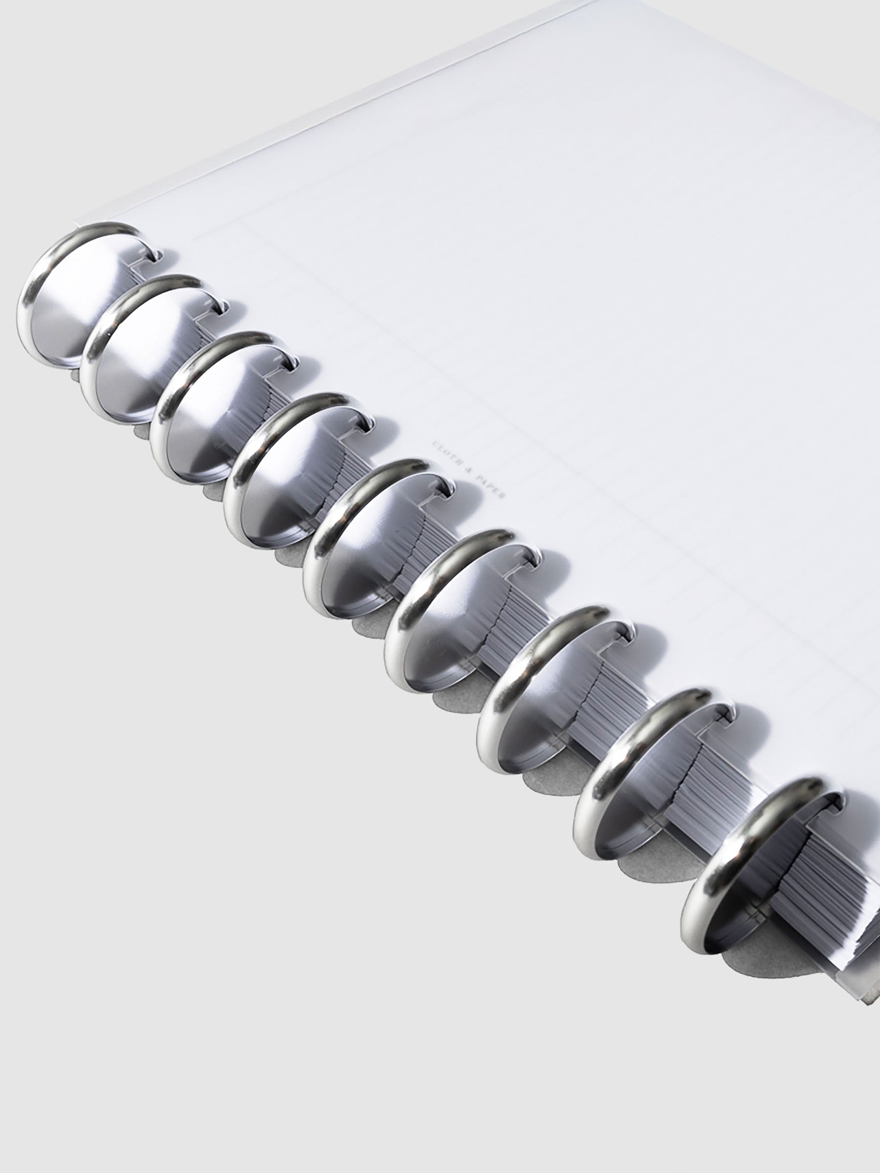 Close-up of silver aluminum planner discs, 1.5 inch size, set of nine stacked together.