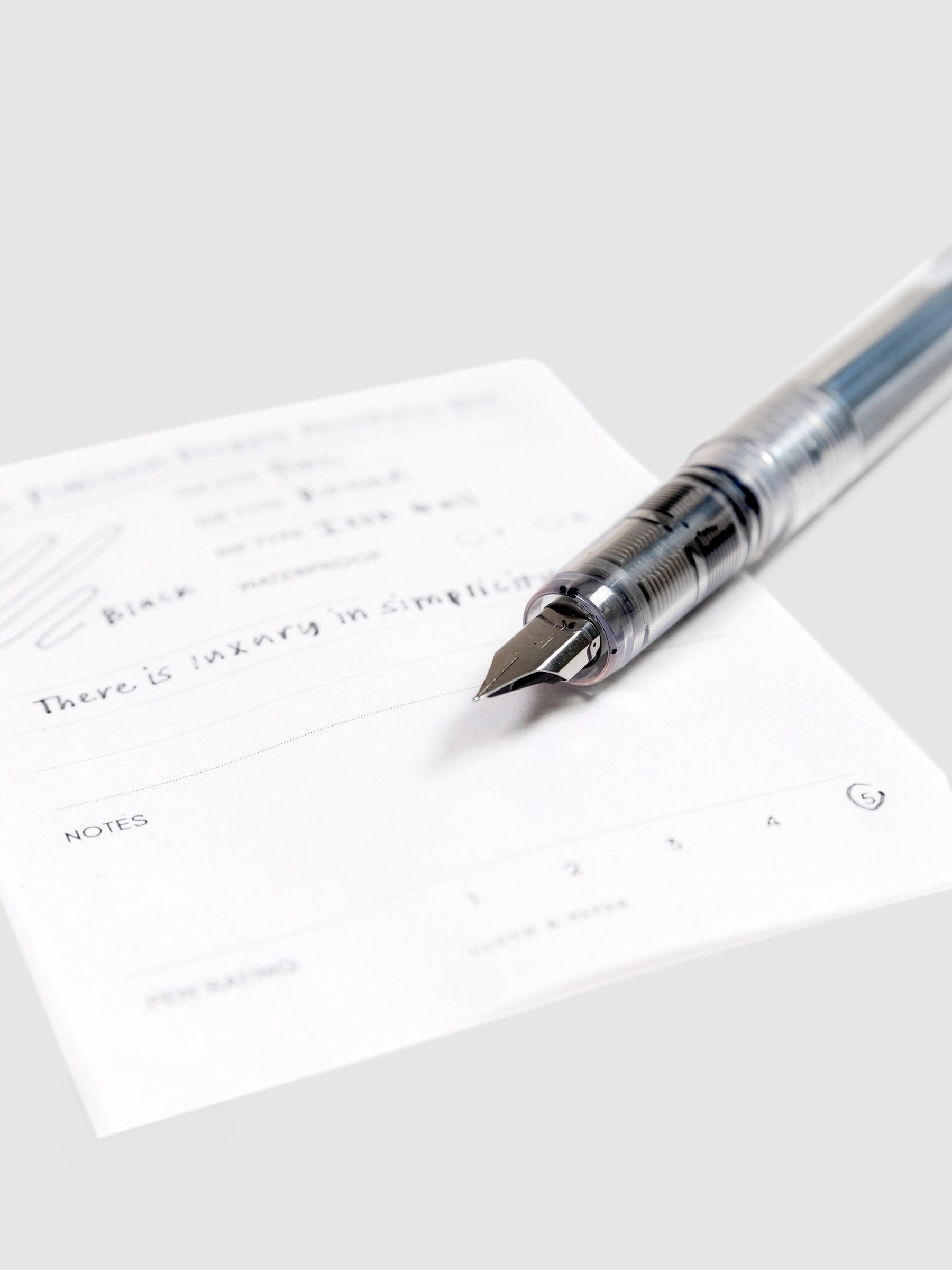 Platinum Preppy Fountain Pen, Crystal, Cloth and Paper. Close up on pen nib resting on pen test sheet.