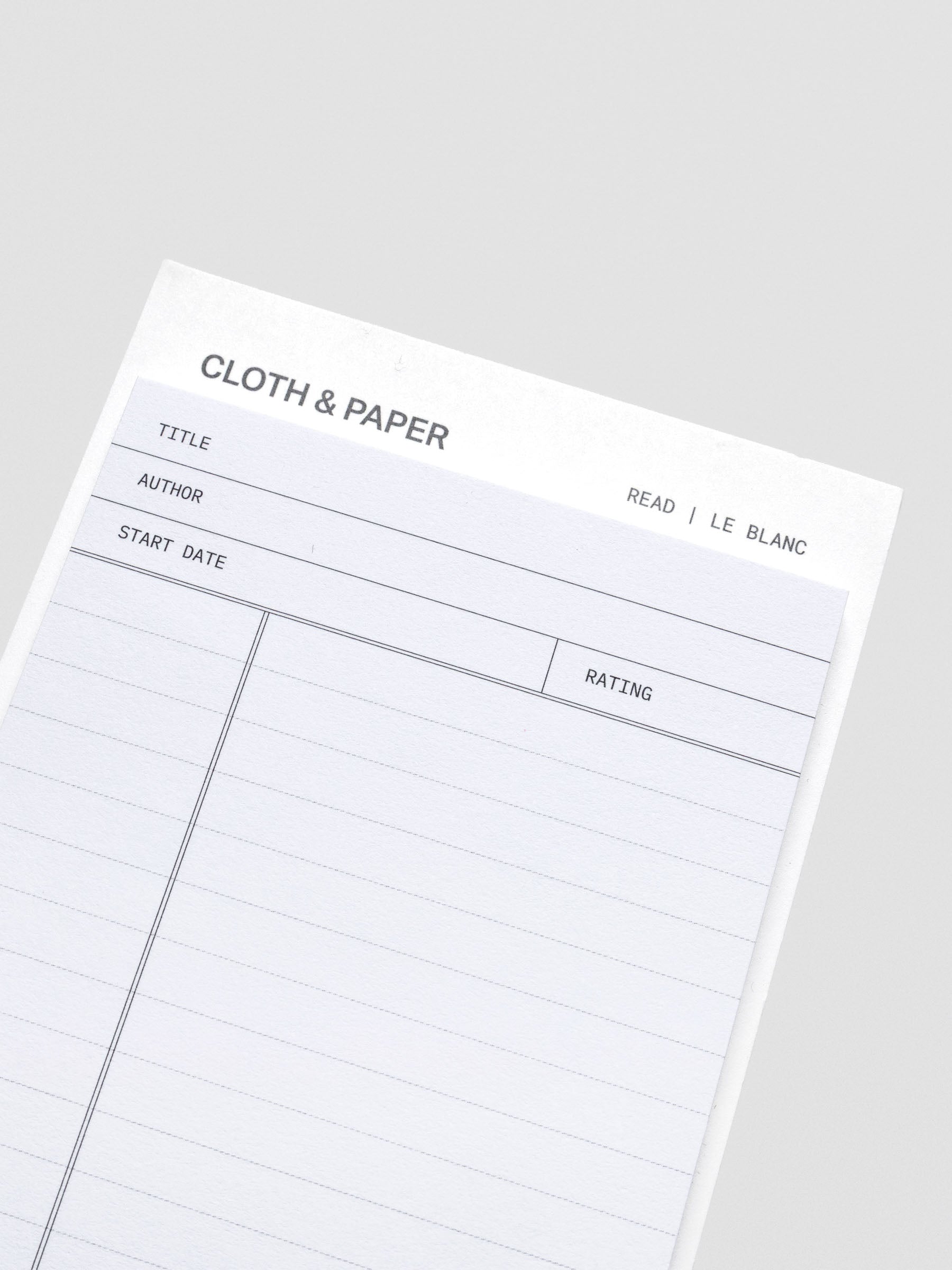 Close up of black and white pad of sticky notes with fields for title, author, start date, rating, and notes section.
