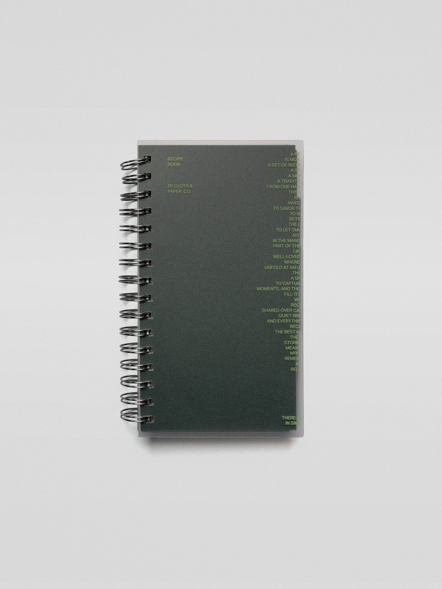 A spiral-bound Recipe Book System with a dark green matte cover featuring minimal lime green text design on the front.