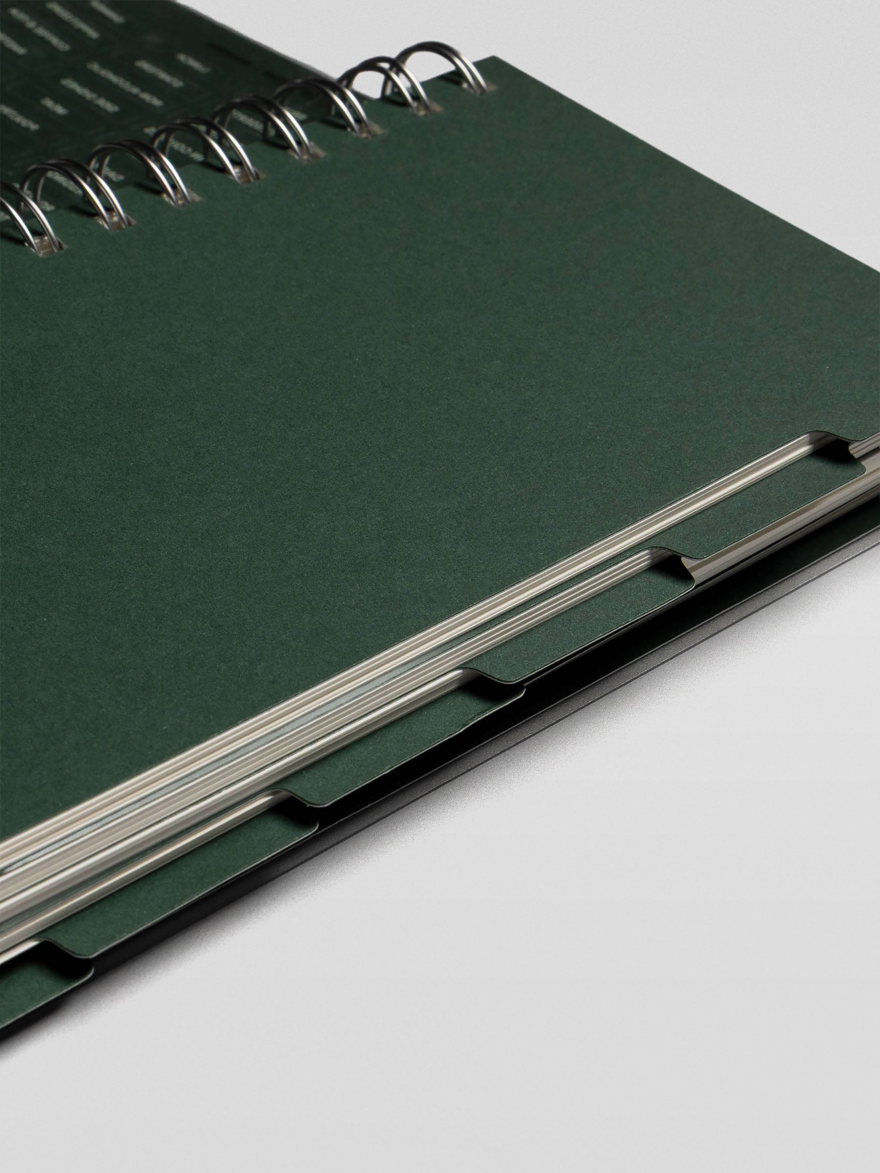 Side view of the Recipe Book System’s tabbed divider pages, showing sturdy green divider tabs within the spiral binding.