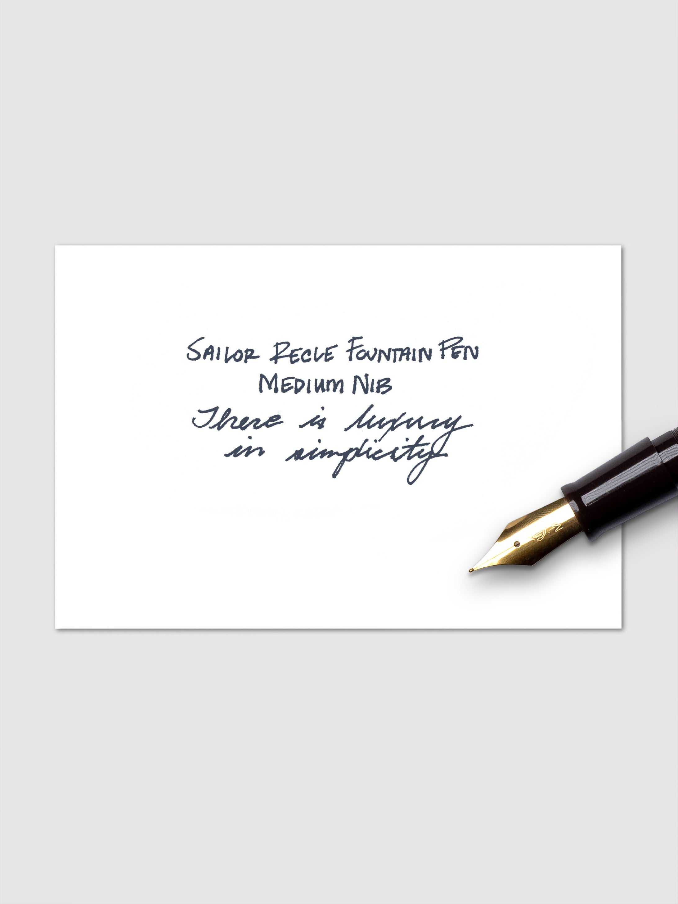 Handwritten example of blue black ink cartridge pictured with the nib of a fountain pen.