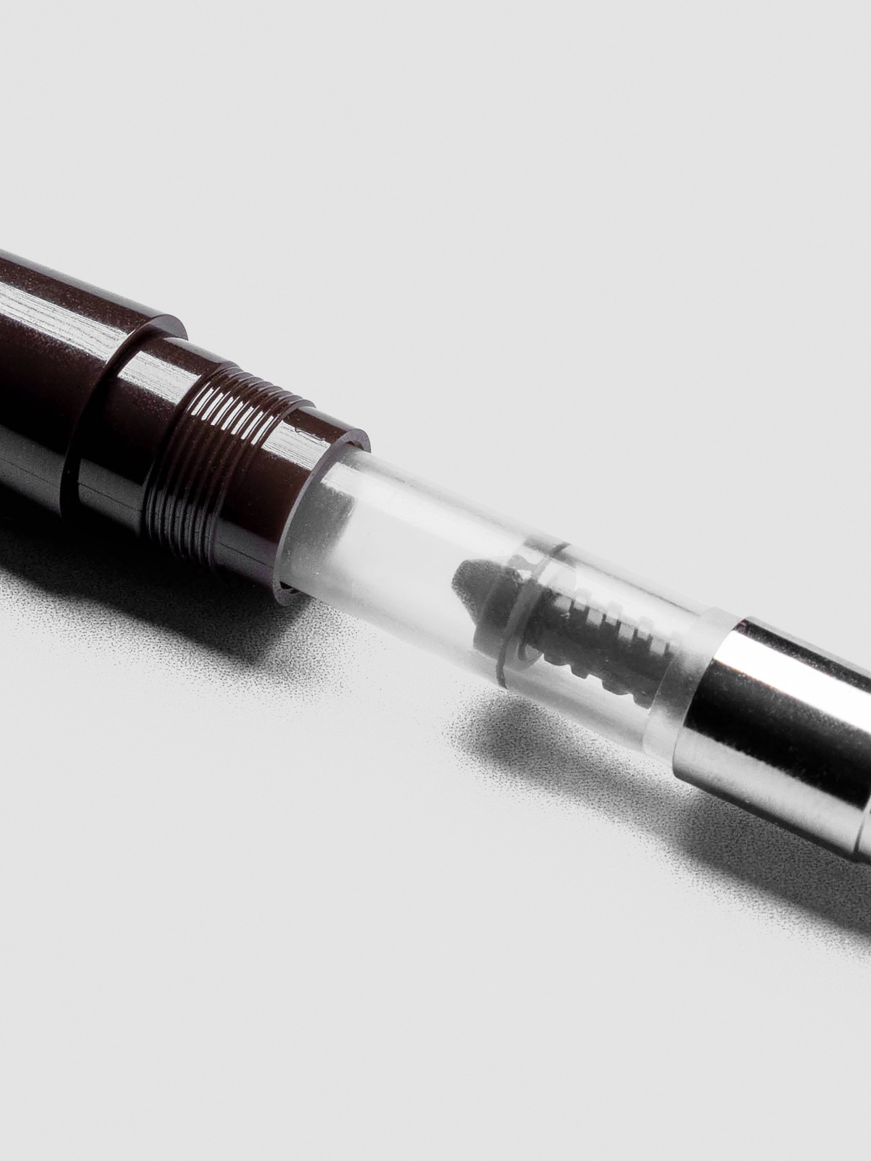 Close view of Sailor Standard Ink Converter highlighting transparent body and piston mechanism.