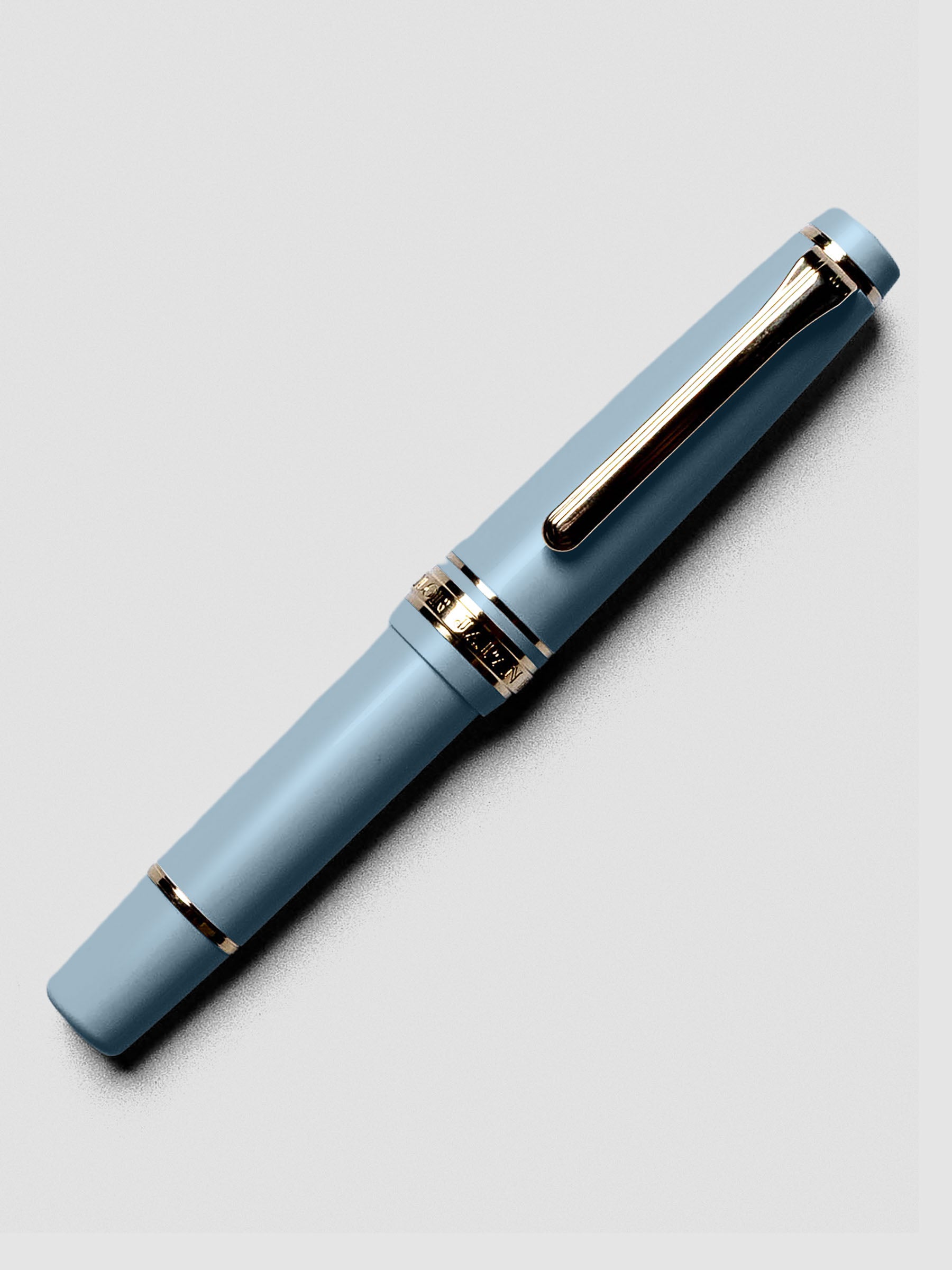 Uncapped Sailor Pro Gear Slim Mini Fountain Pen in Ayur Blue with nib exposed.