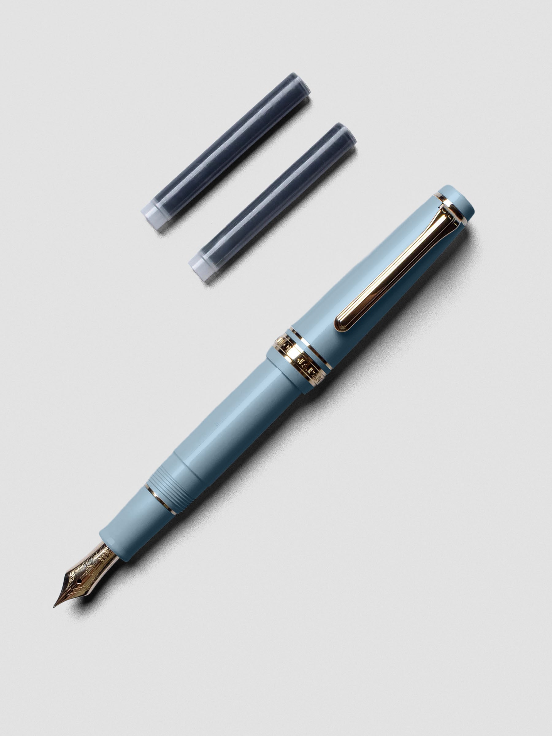 Sailor Pro Gear Slim Mini Fountain Pen in Ayur Blue with cap posted on the back.