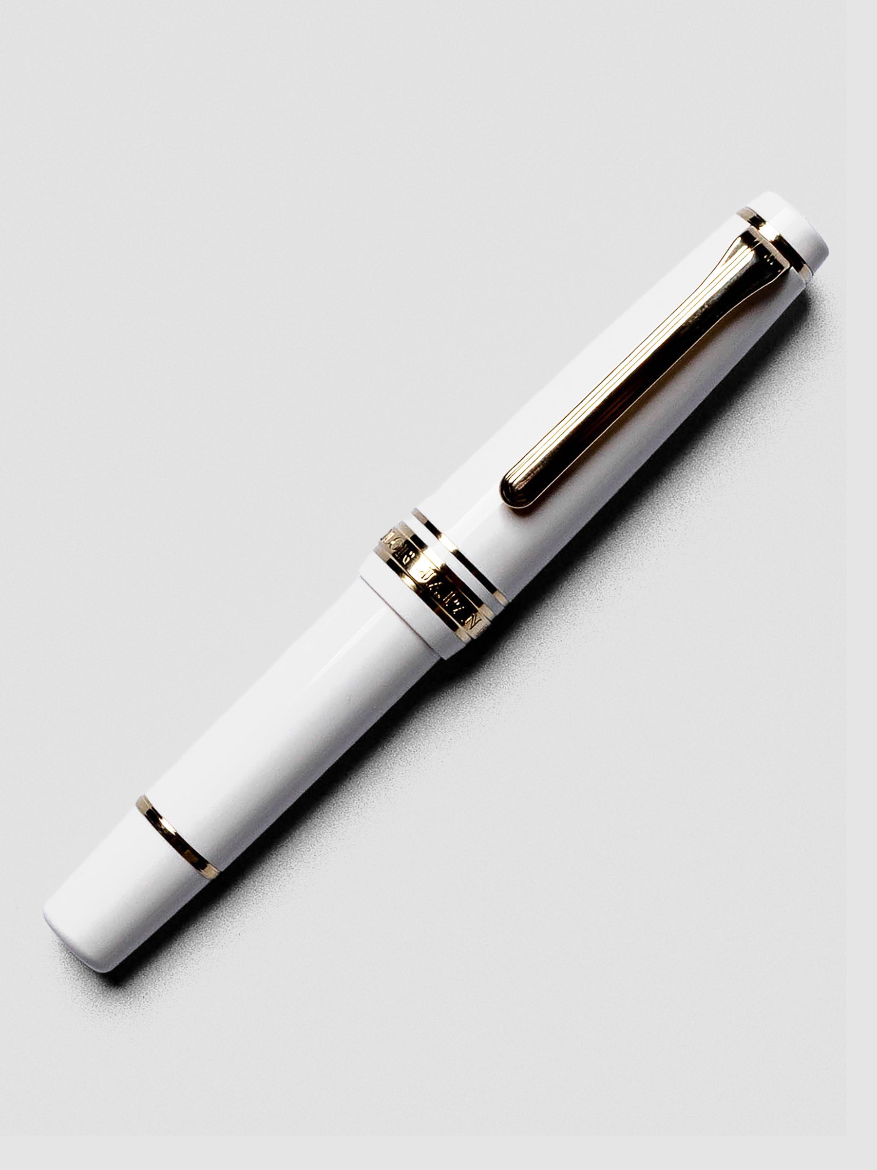 Uncapped Sailor Pro Gear Slim Mini Fountain Pen in Beni White with nib revealed.