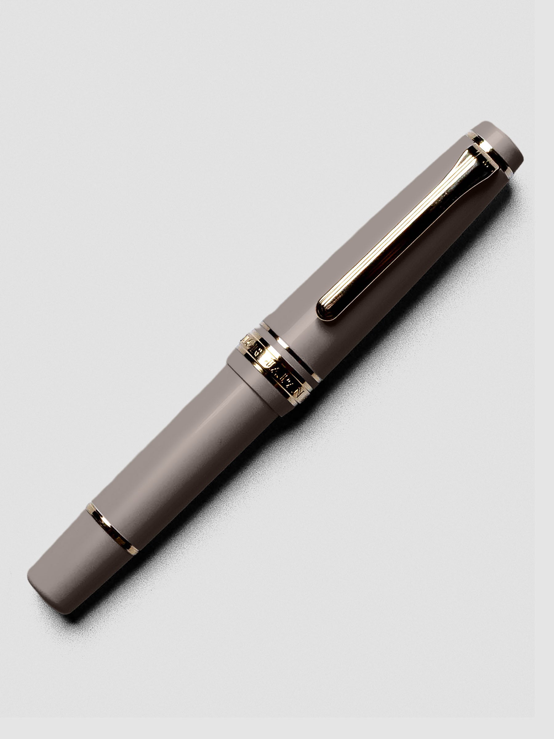 Uncapped Sailor Pro Gear Slim Mini Fountain Pen in Puff Brown with nib visible.