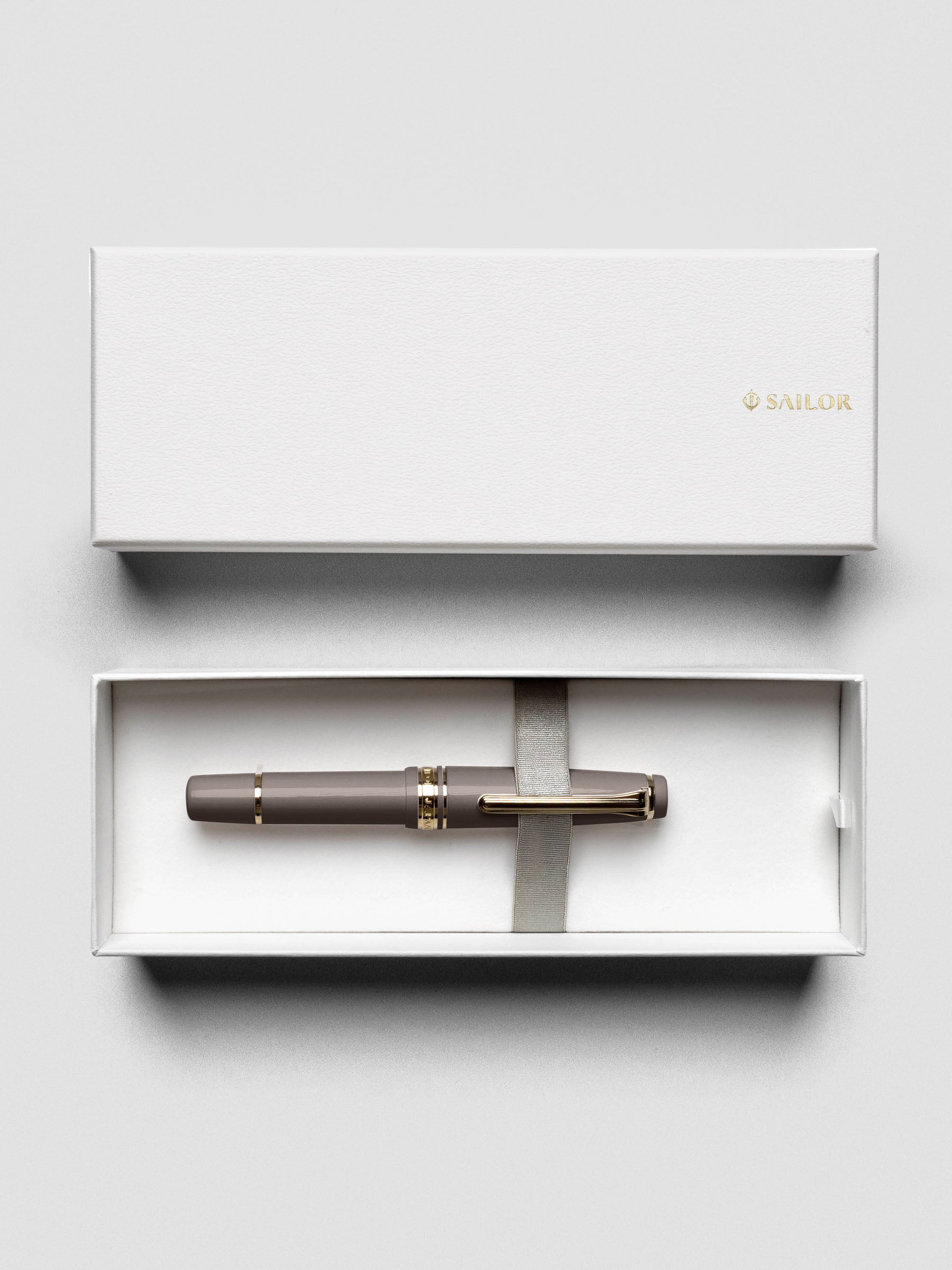 Overhead view of Sailor Pro Gear Slim Mini Fountain Pen in Puff Brown with cap beside pen.